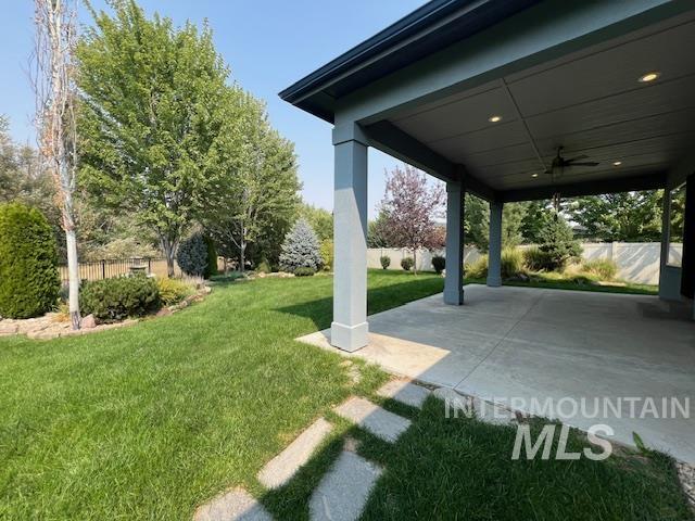 View of yard featuring ceiling fan and a patio
