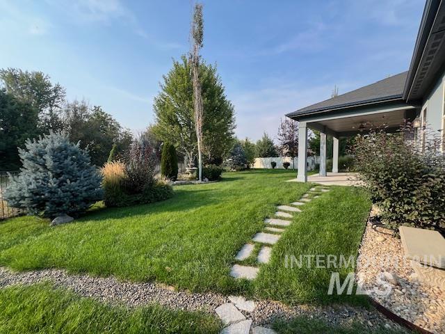 View of grassy yard featuring a patio area