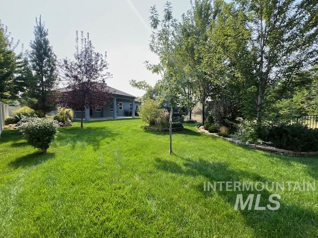 View of grassy yard with a patio area