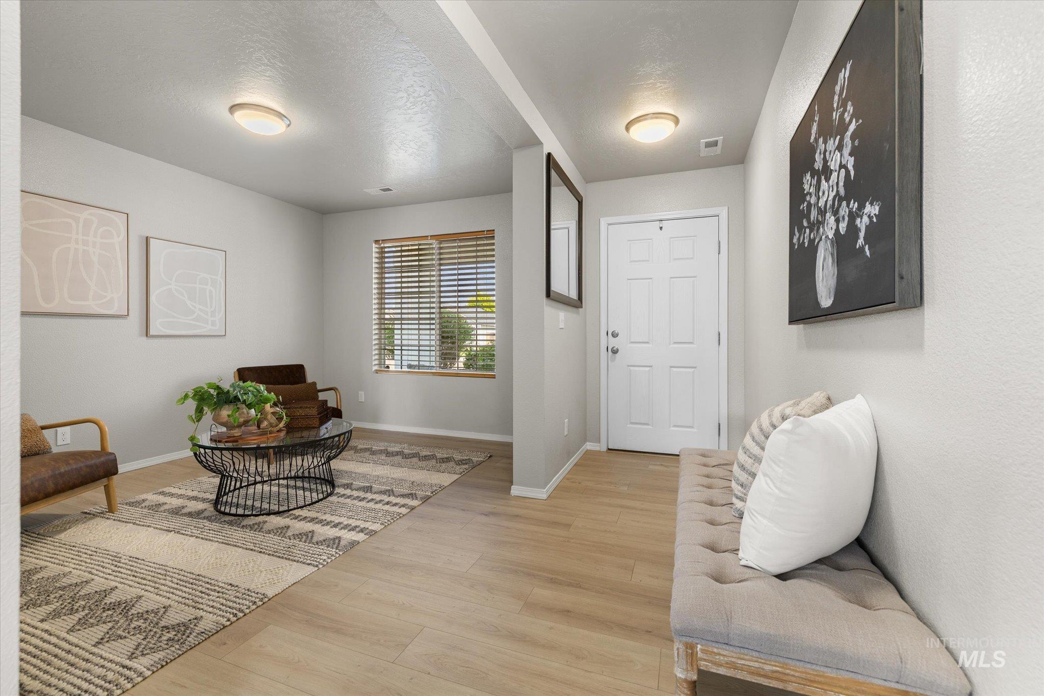 Entryway with light wood-type flooring and a textured ceiling