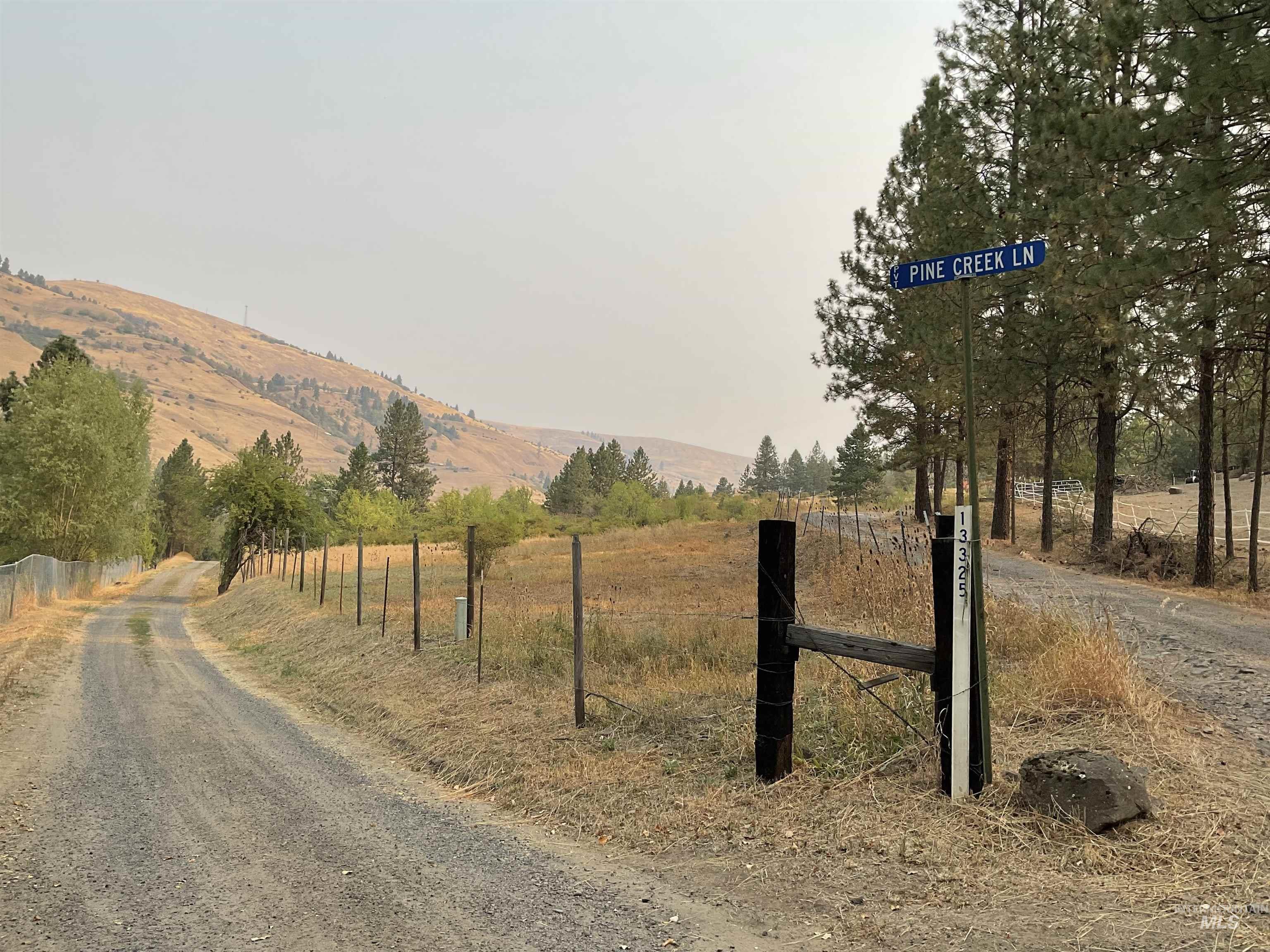 View of dirt / gravel road featuring a view of rural / pastoral area