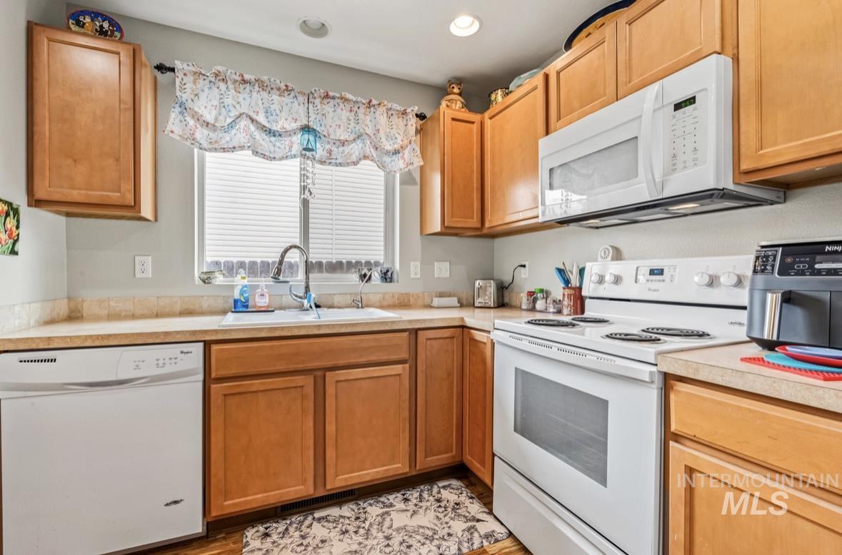 Kitchen featuring white appliances, light countertops, and recessed lighting