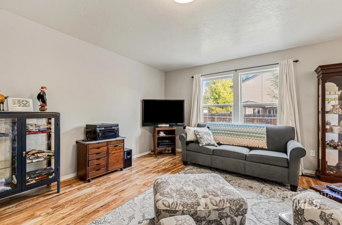 Living area featuring light wood finished floors and a textured ceiling