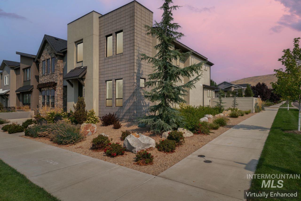Property exterior at dusk featuring stucco siding and stone siding