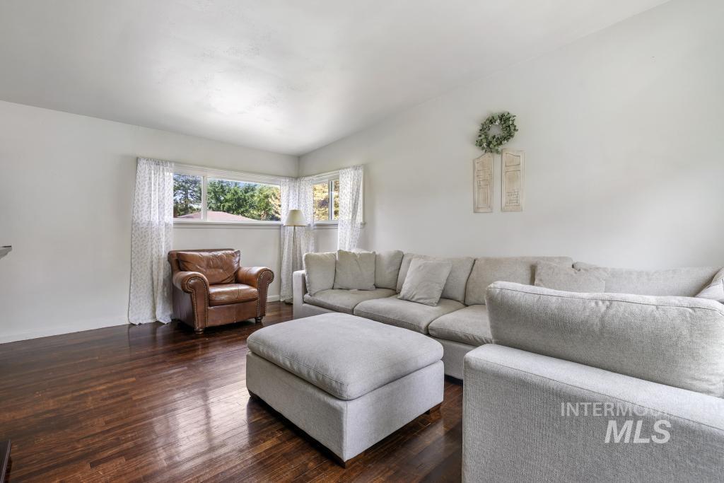 Living area featuring vaulted ceiling and dark wood-style floors