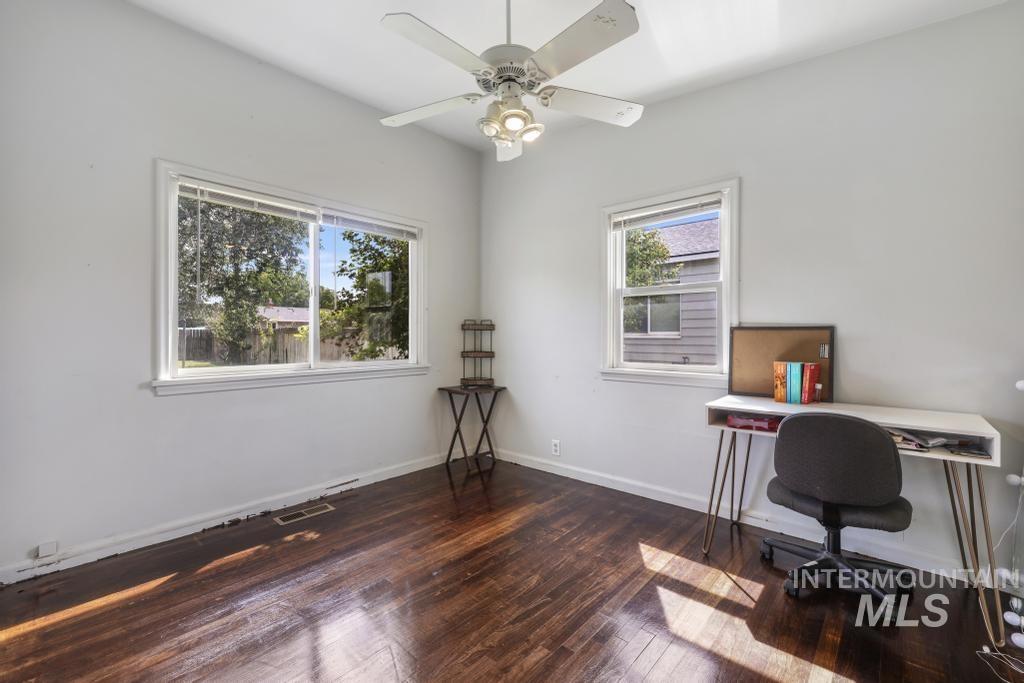 Office area featuring dark wood-style flooring and a ceiling fan