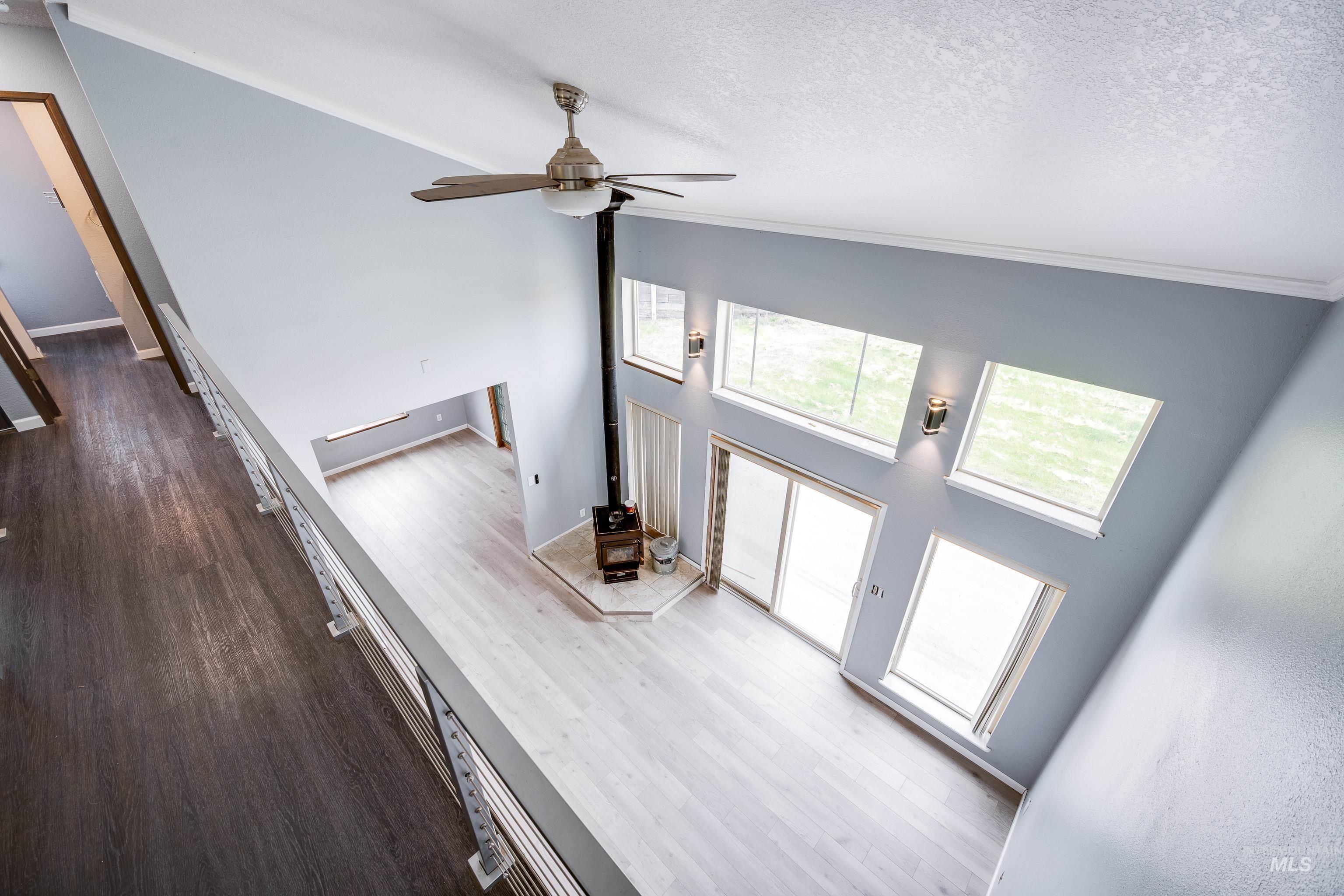 Foyer entrance featuring high vaulted ceiling, dark wood-type flooring, healthy amount of natural light, ceiling fan, and a textured ceiling