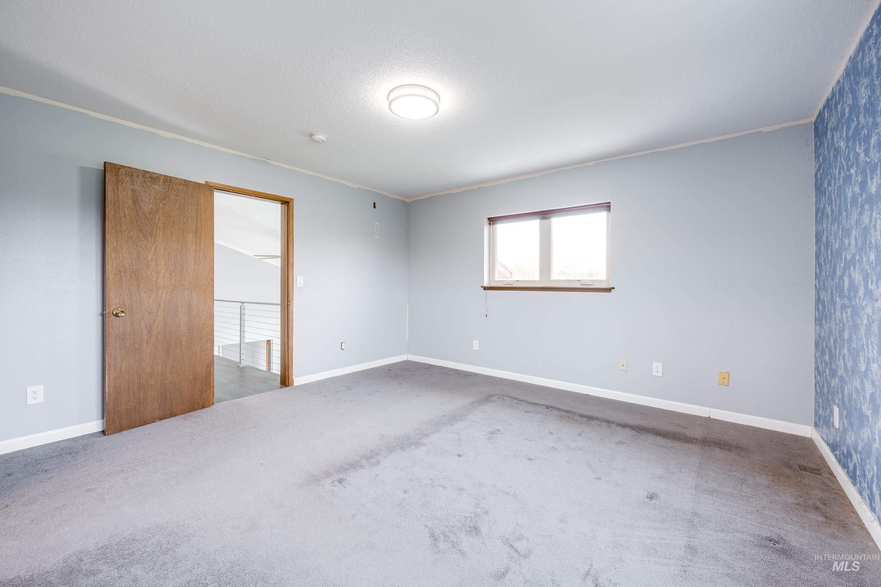 Carpeted spare room with baseboards and crown molding