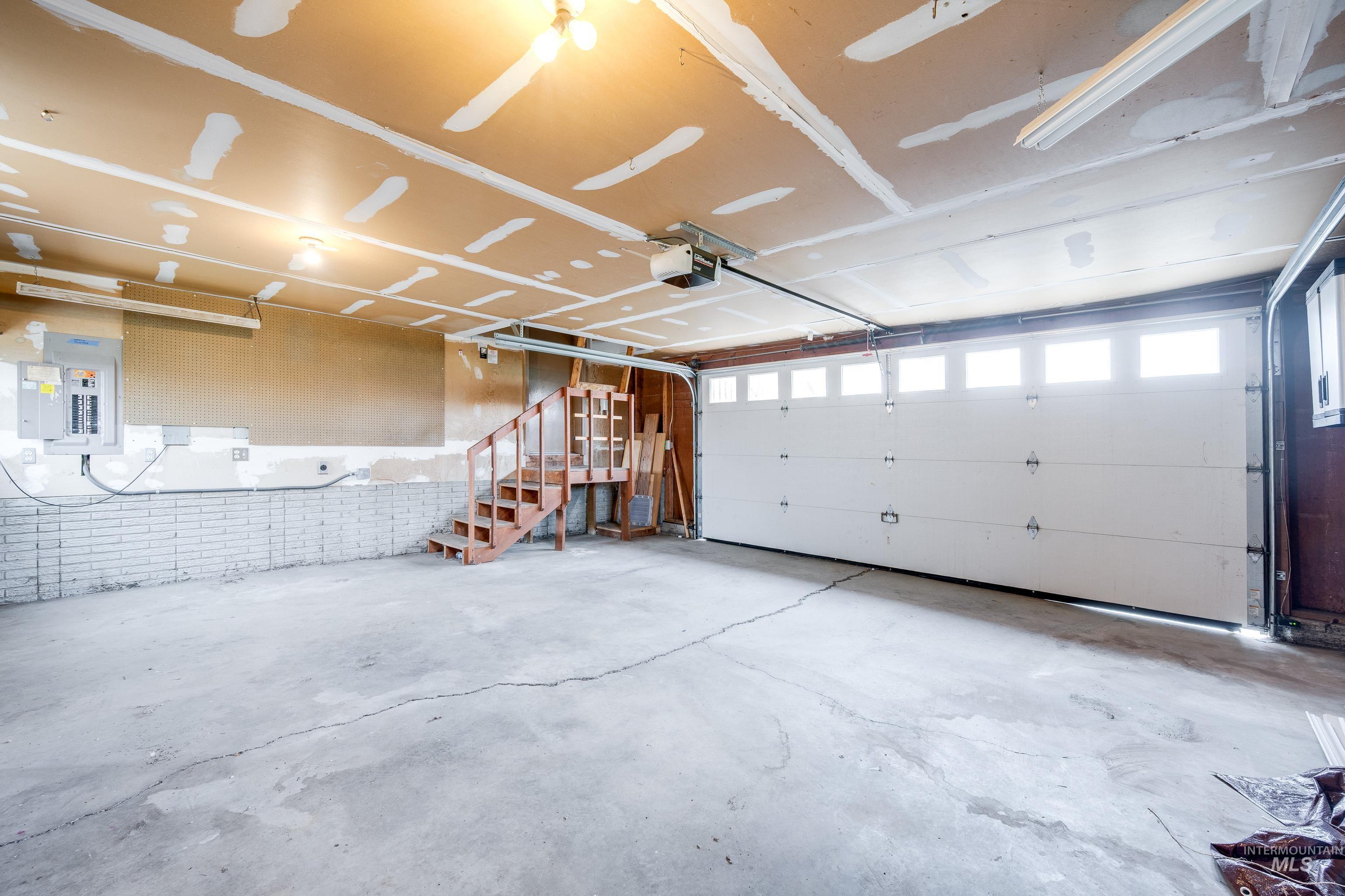 Garage with electric panel and a garage door opener