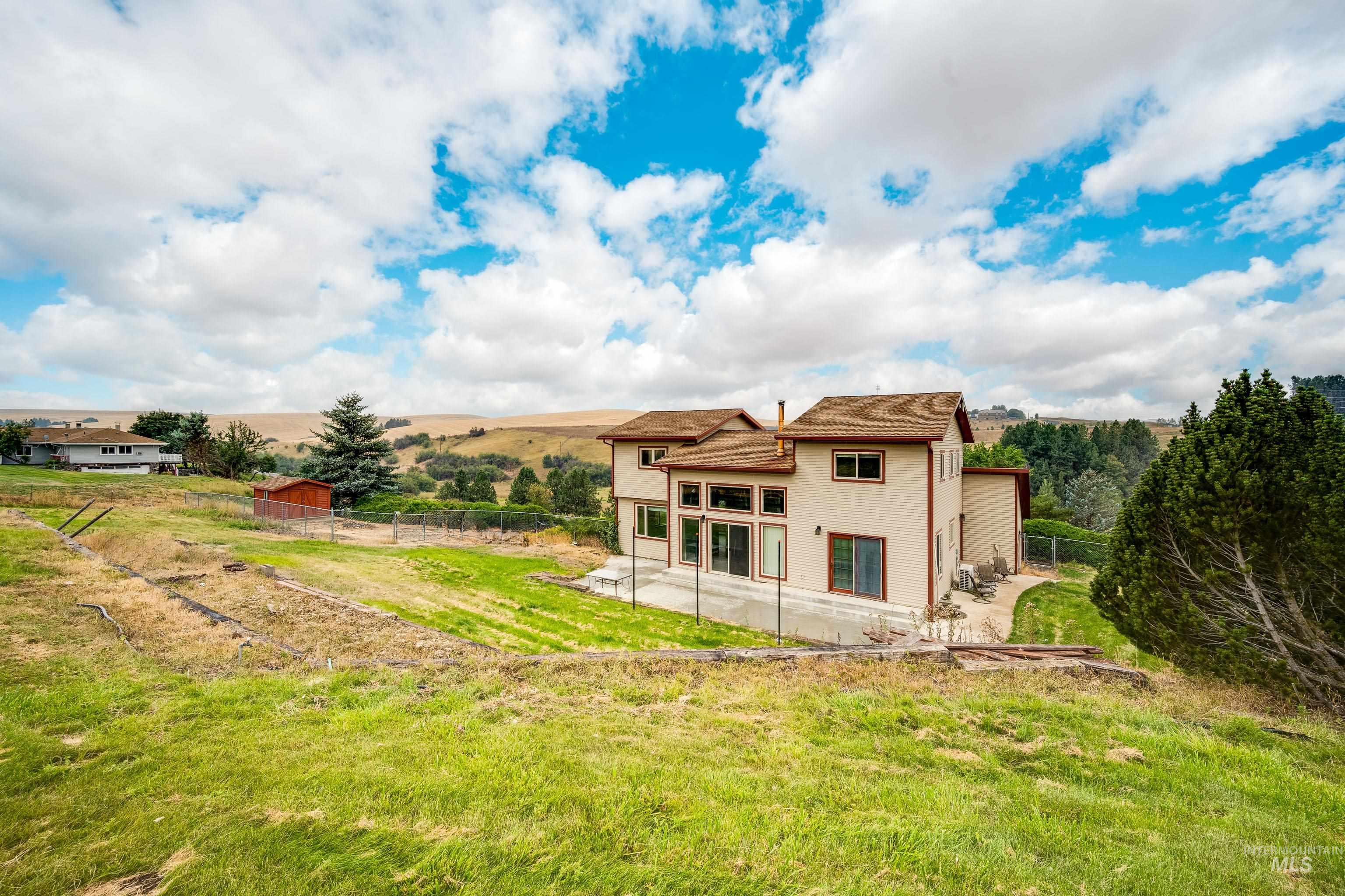 Rear view of house featuring a patio and a view of countryside