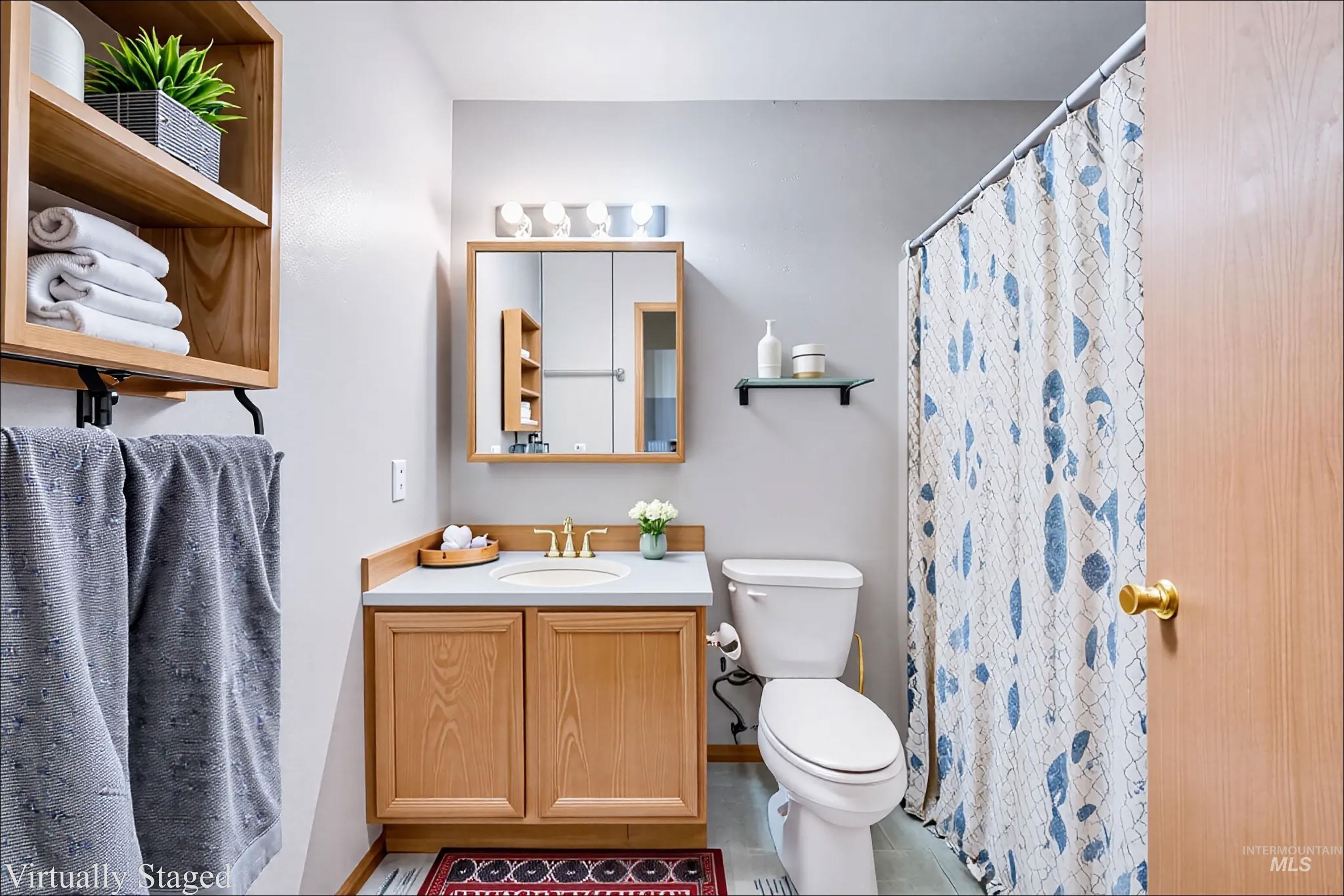 Full bath featuring vanity, light tile patterned floors, and curtained shower