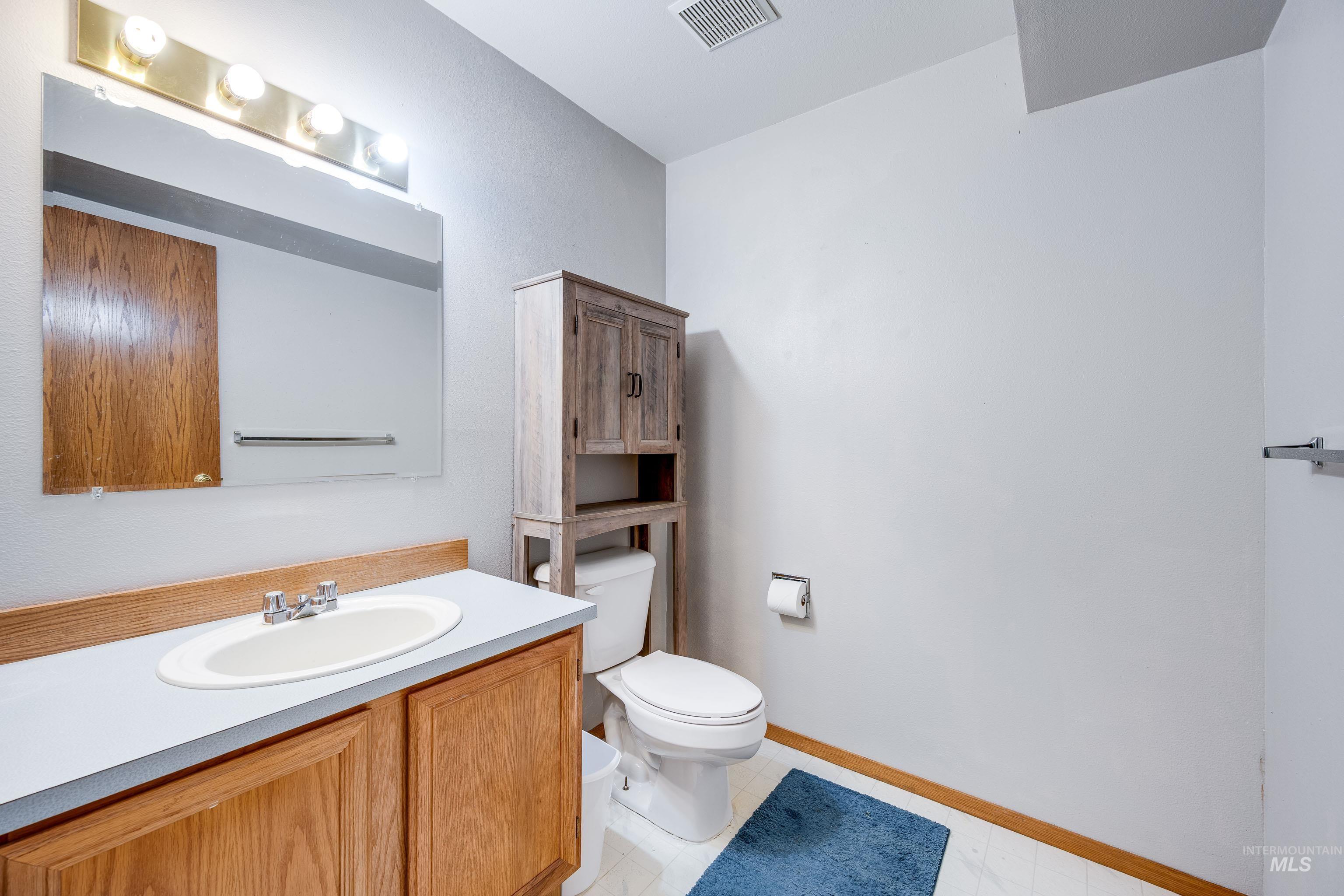 Half bathroom featuring vanity and light tile patterned floors