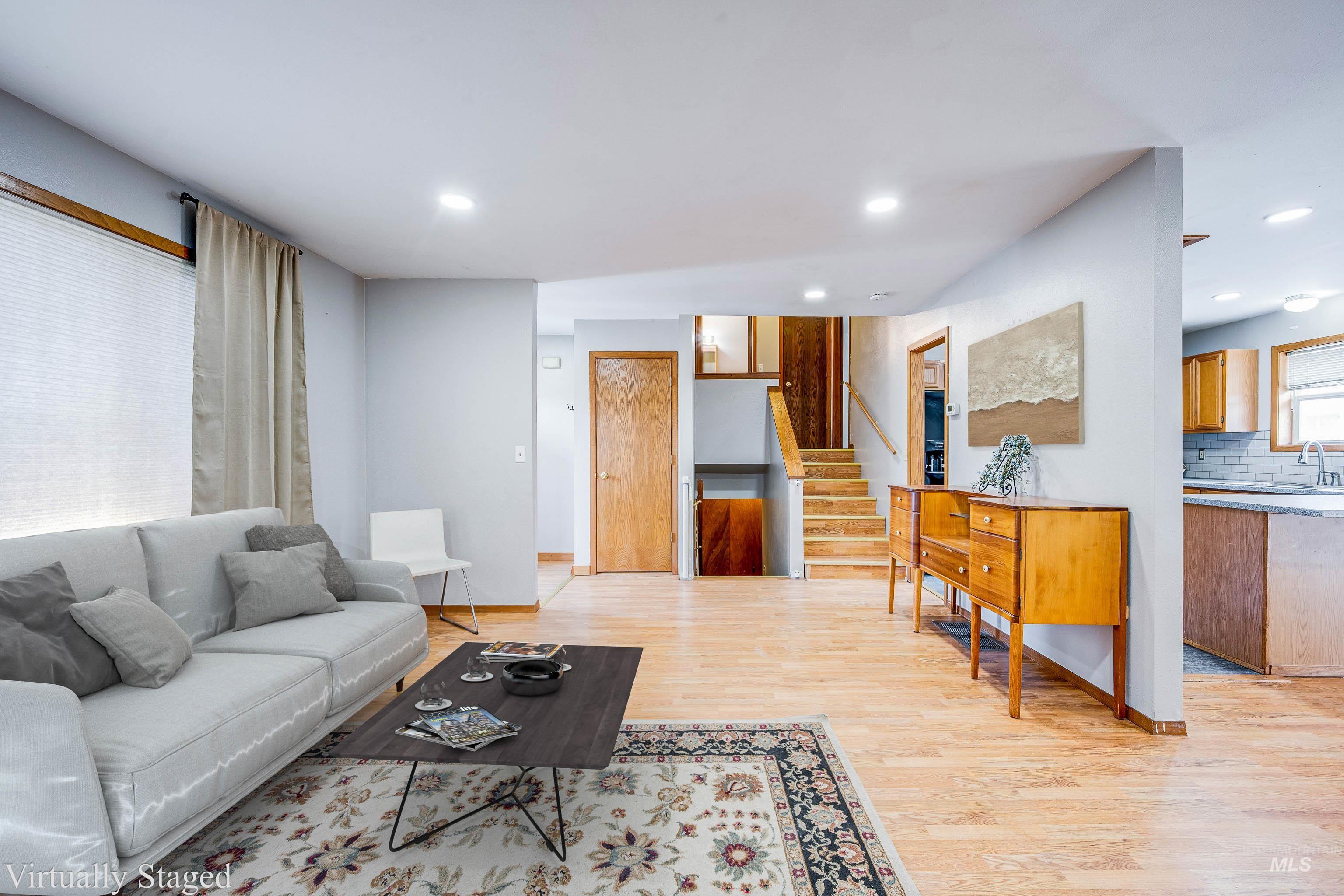 Living room with light wood-type flooring, stairway, and recessed lighting