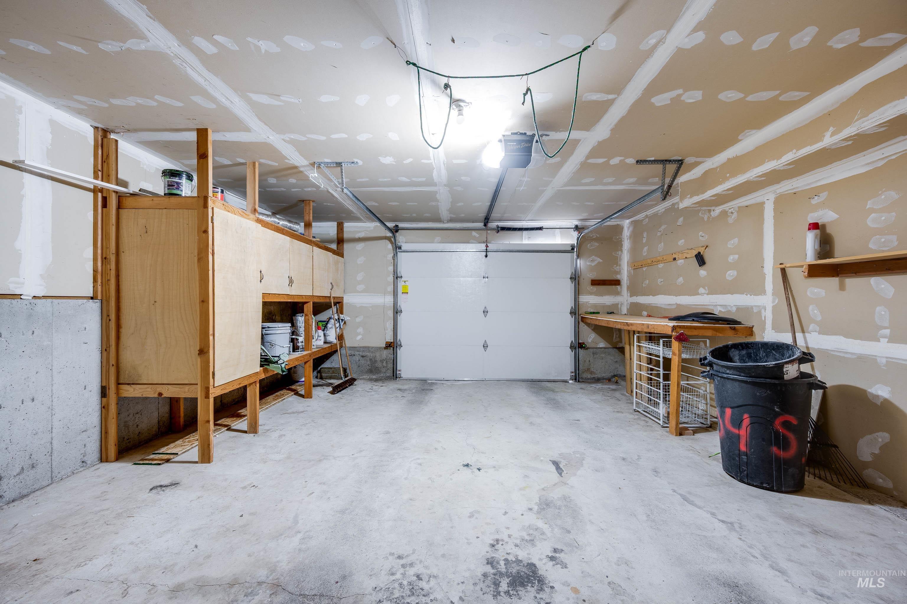 Garage featuring a garage door opener and a workshop area