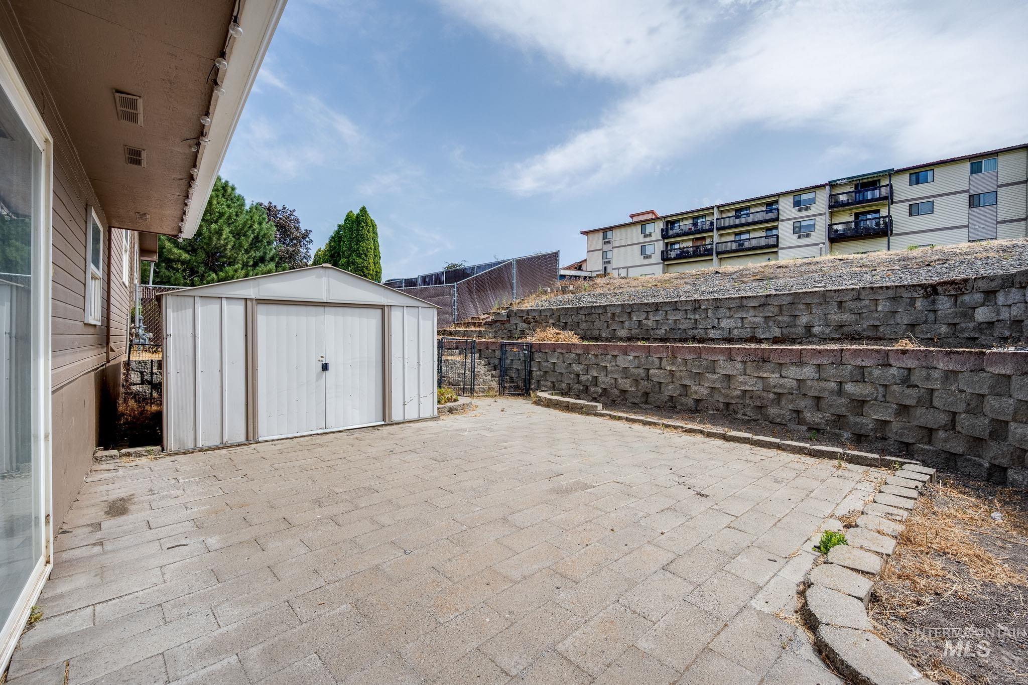 Fenced backyard with a patio area and a shed