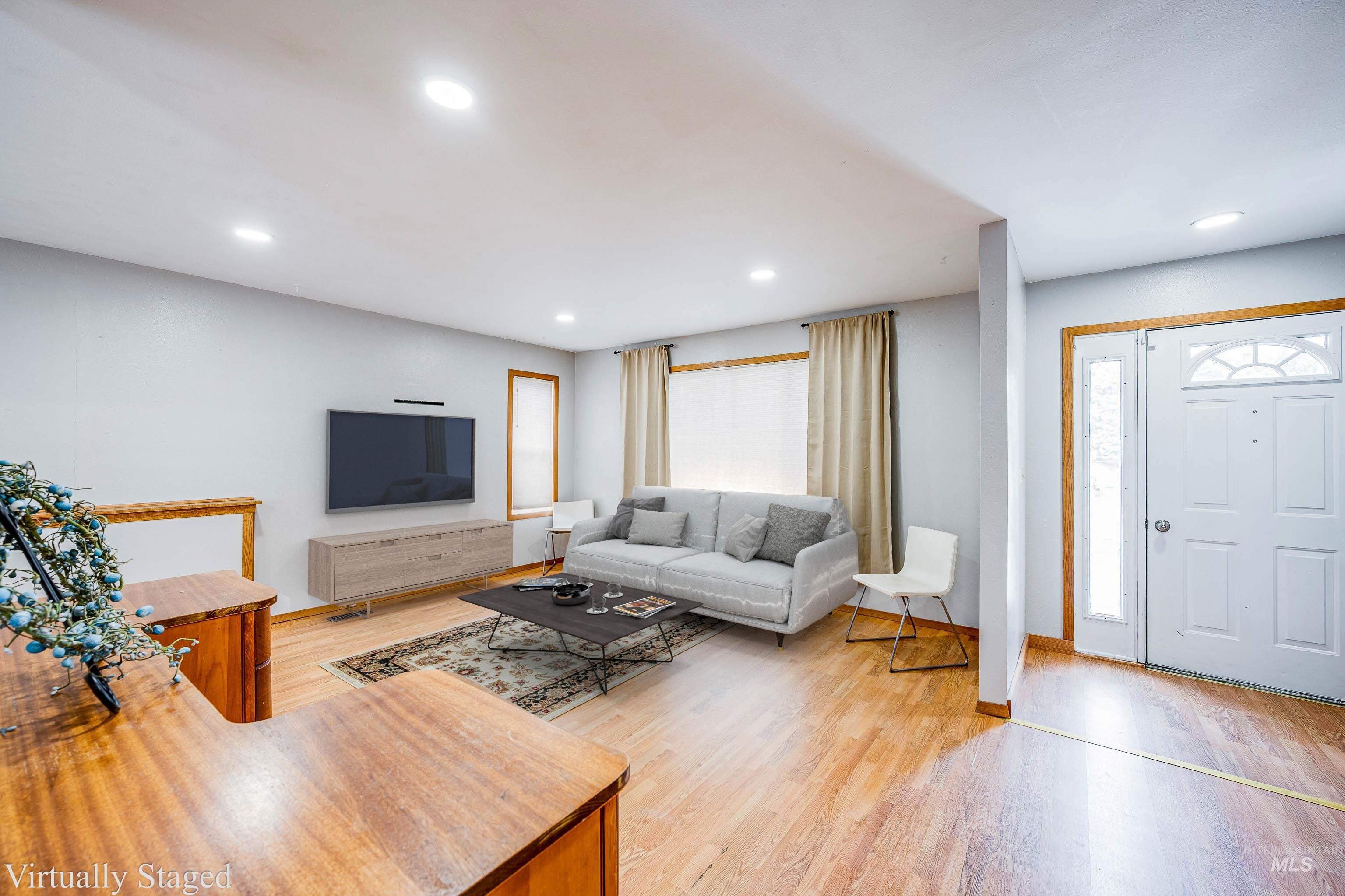 Living room with light wood-style floors and recessed lighting