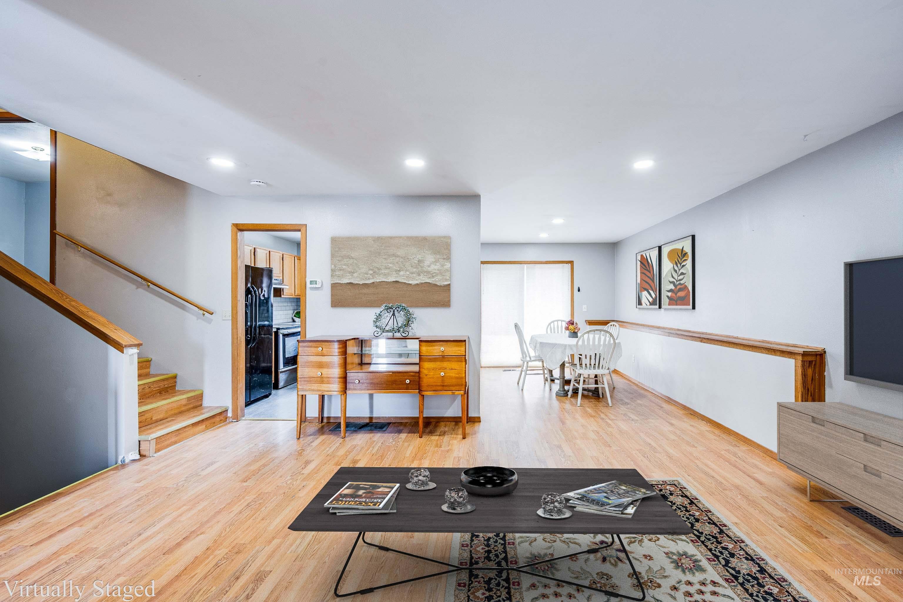 Living room featuring stairs, light wood finished floors, and recessed lighting