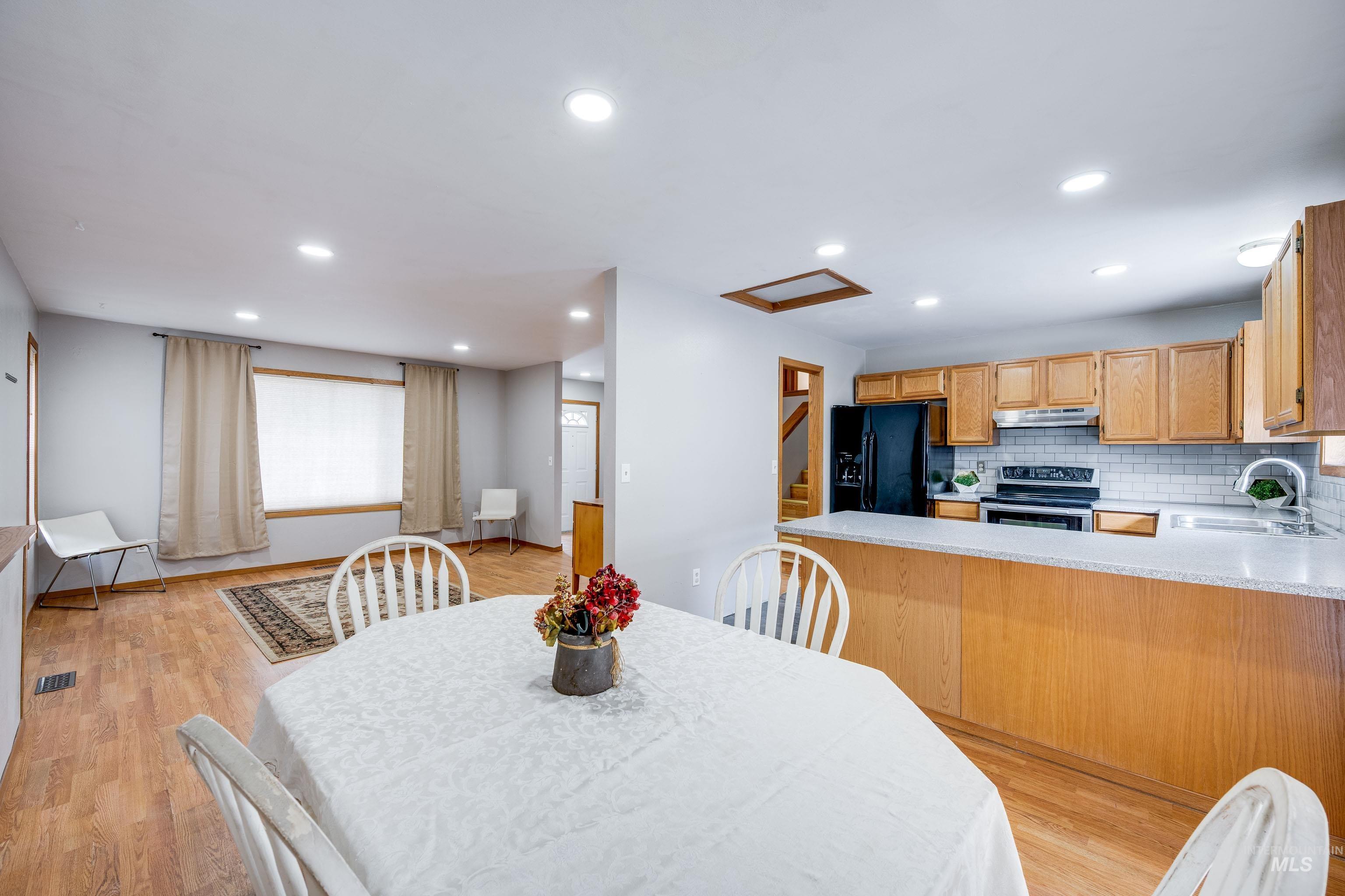 Dining room with light wood-type flooring, recessed lighting, and attic access