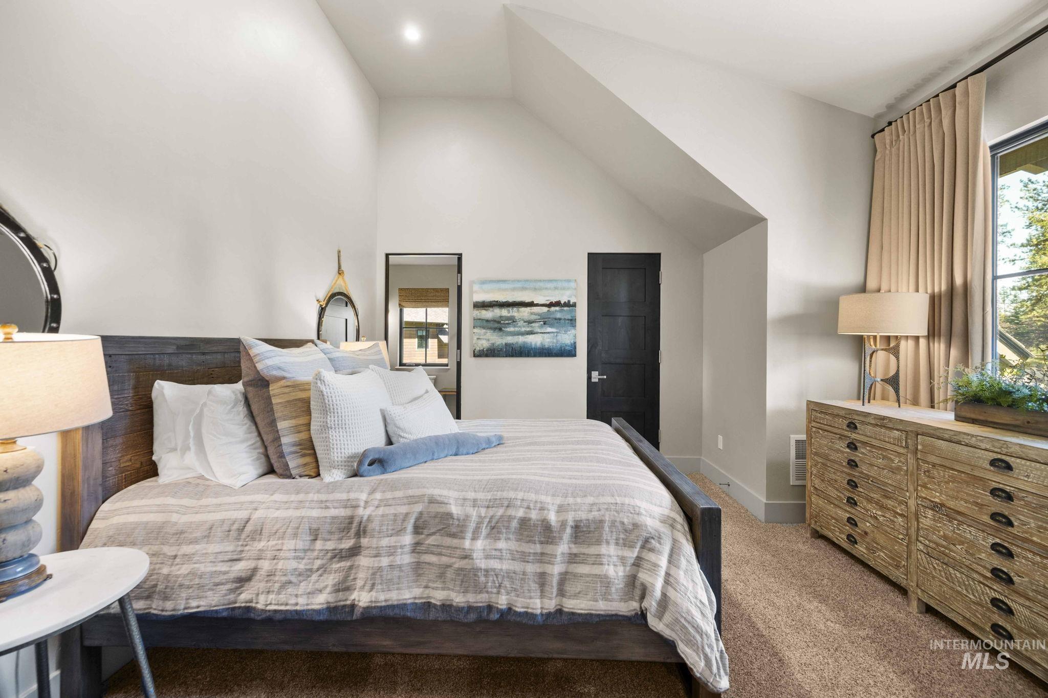 Bedroom featuring carpet floors and lofted ceiling
