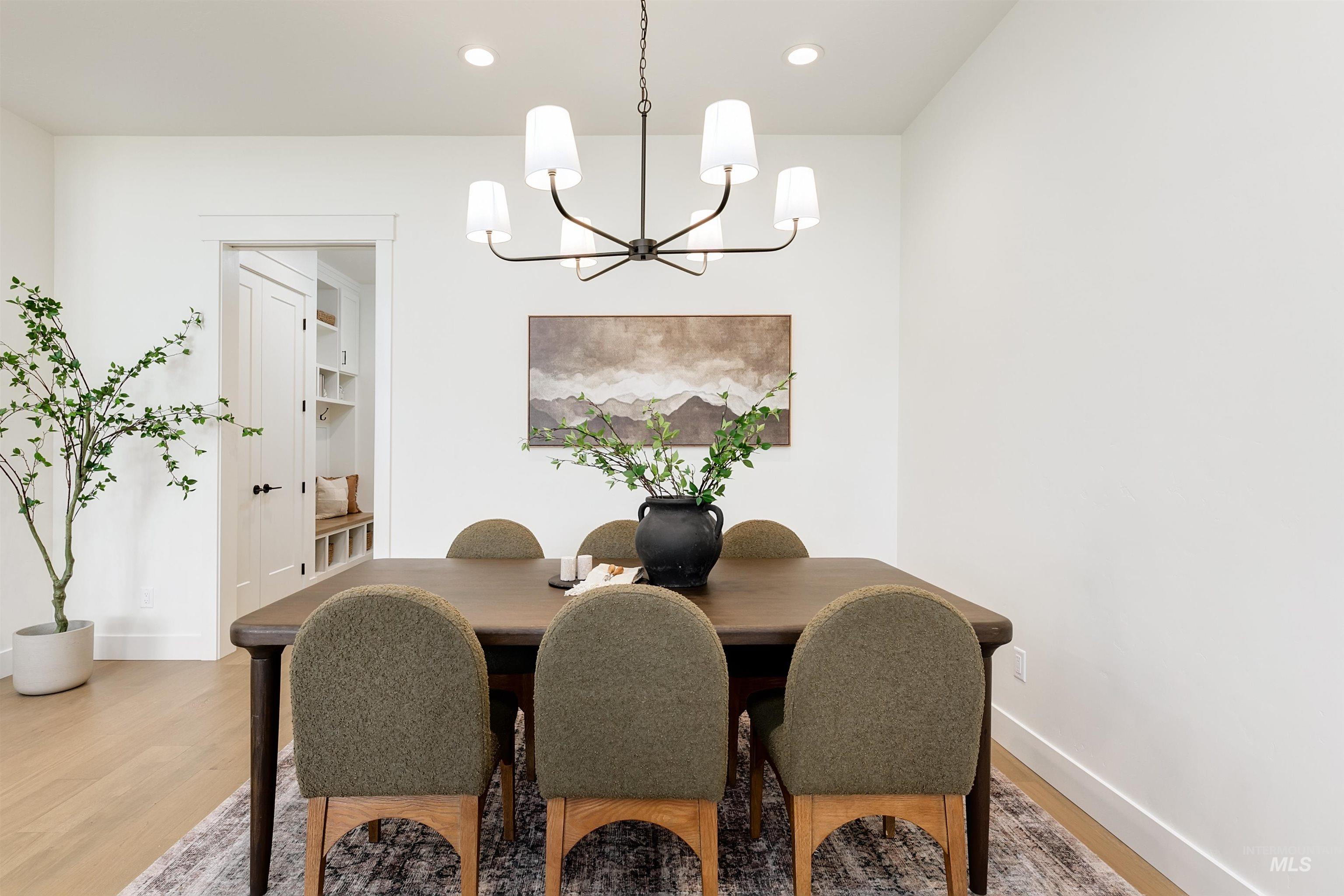 Dining area with light wood-style flooring, recessed lighting, and a chandelier