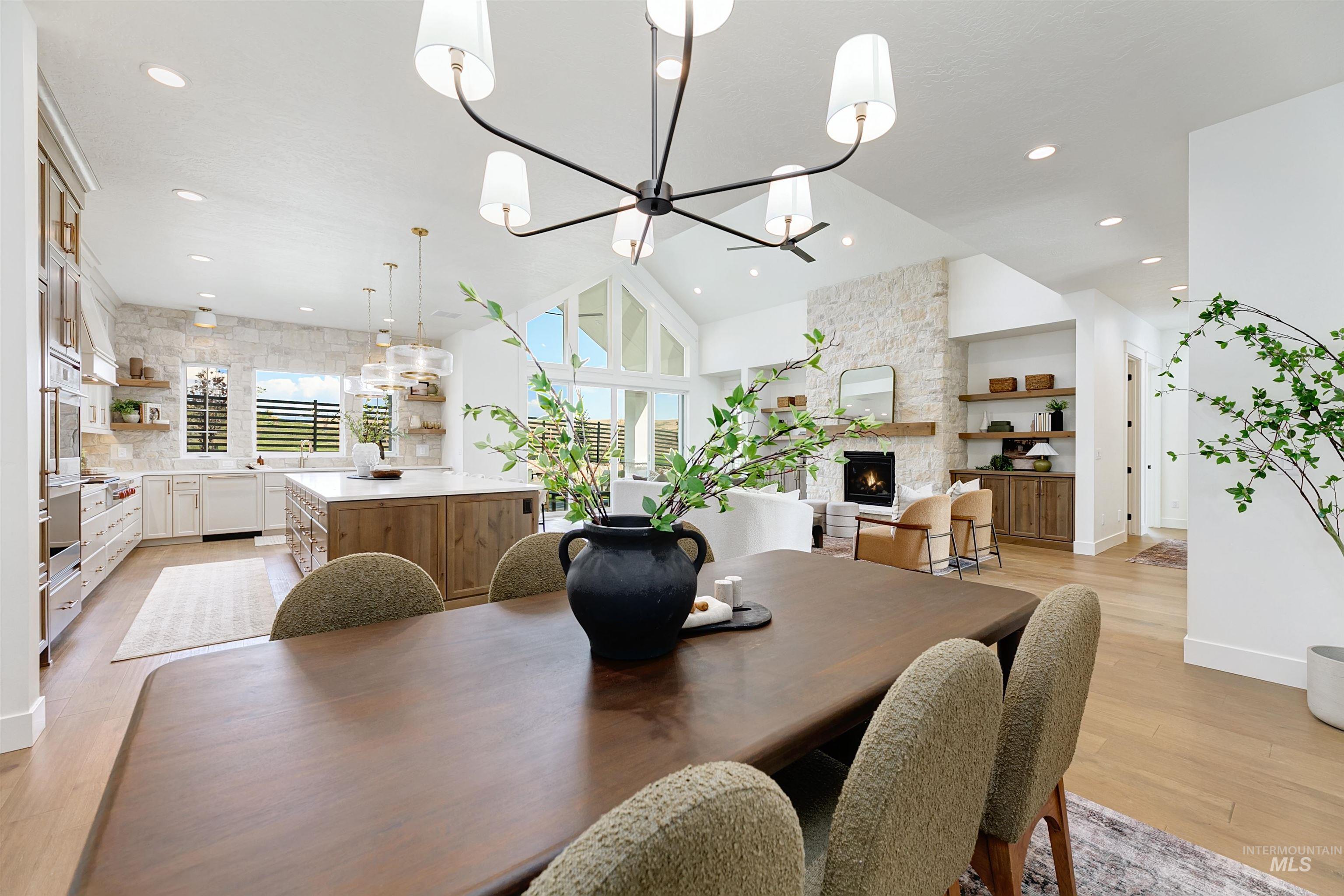 Dining space with light wood-style floors, a chandelier, a fireplace, and recessed lighting