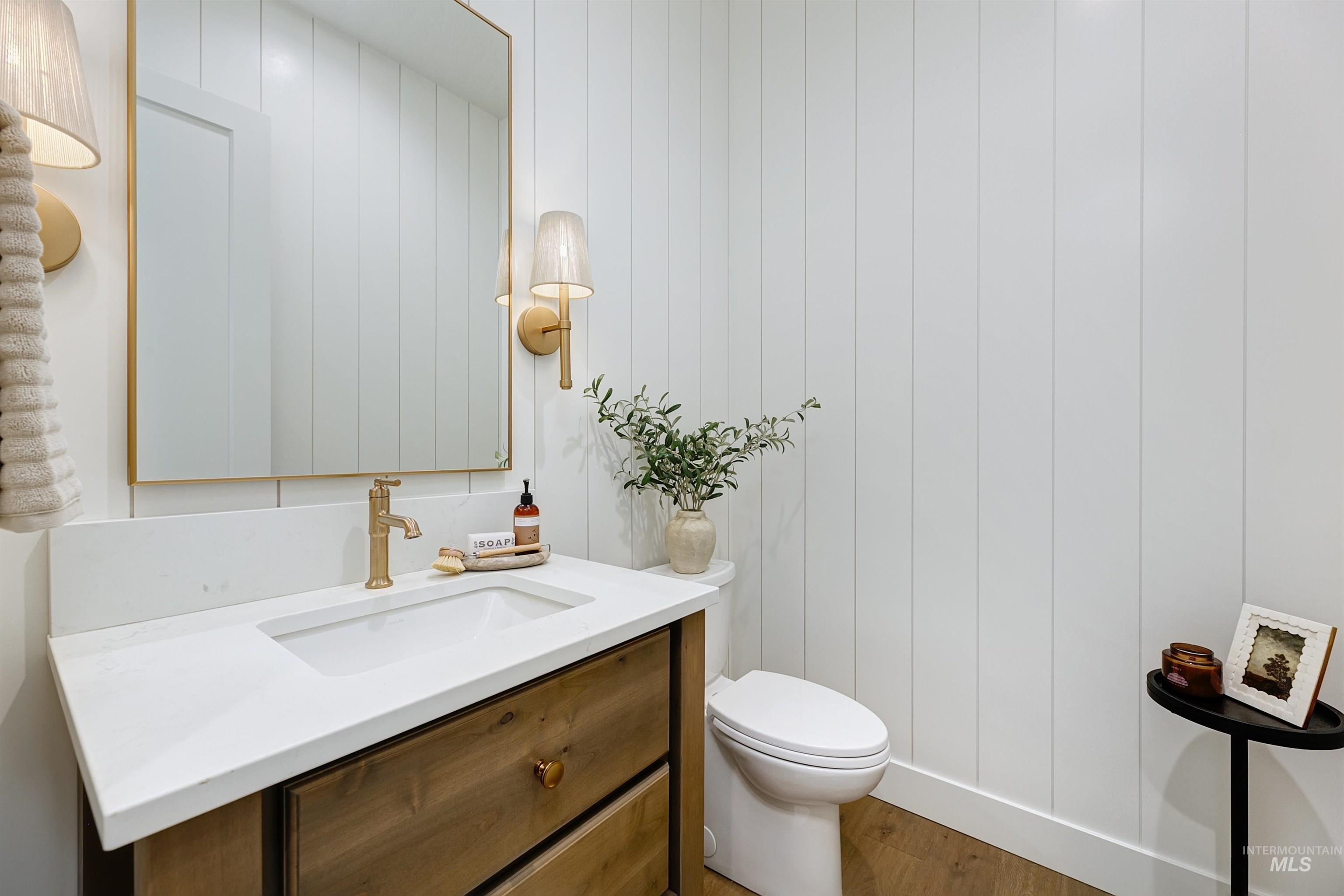 Half bath featuring wood finished floors and vanity