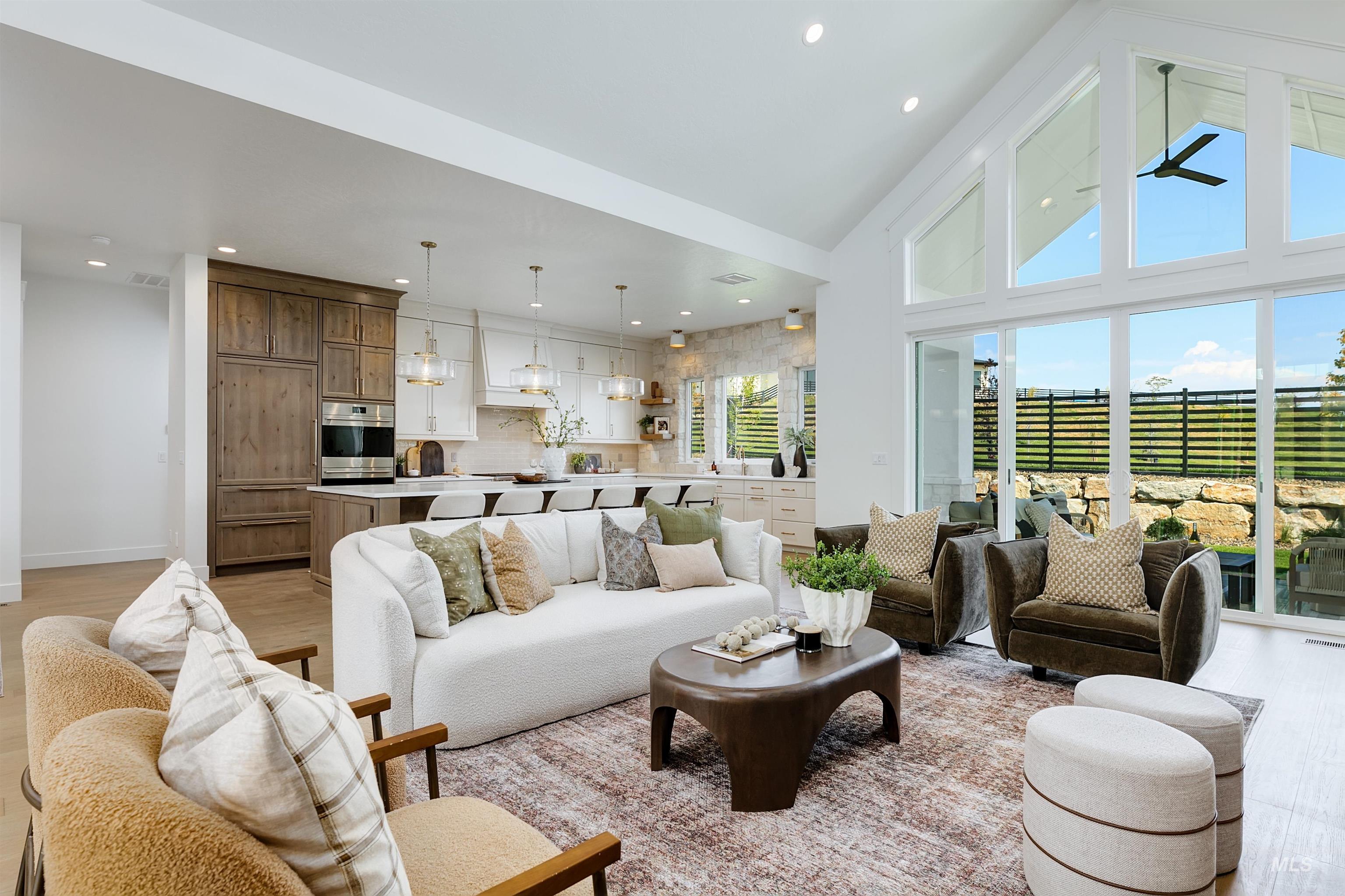 Living room featuring high vaulted ceiling, recessed lighting, light wood-style floors, and ceiling fan