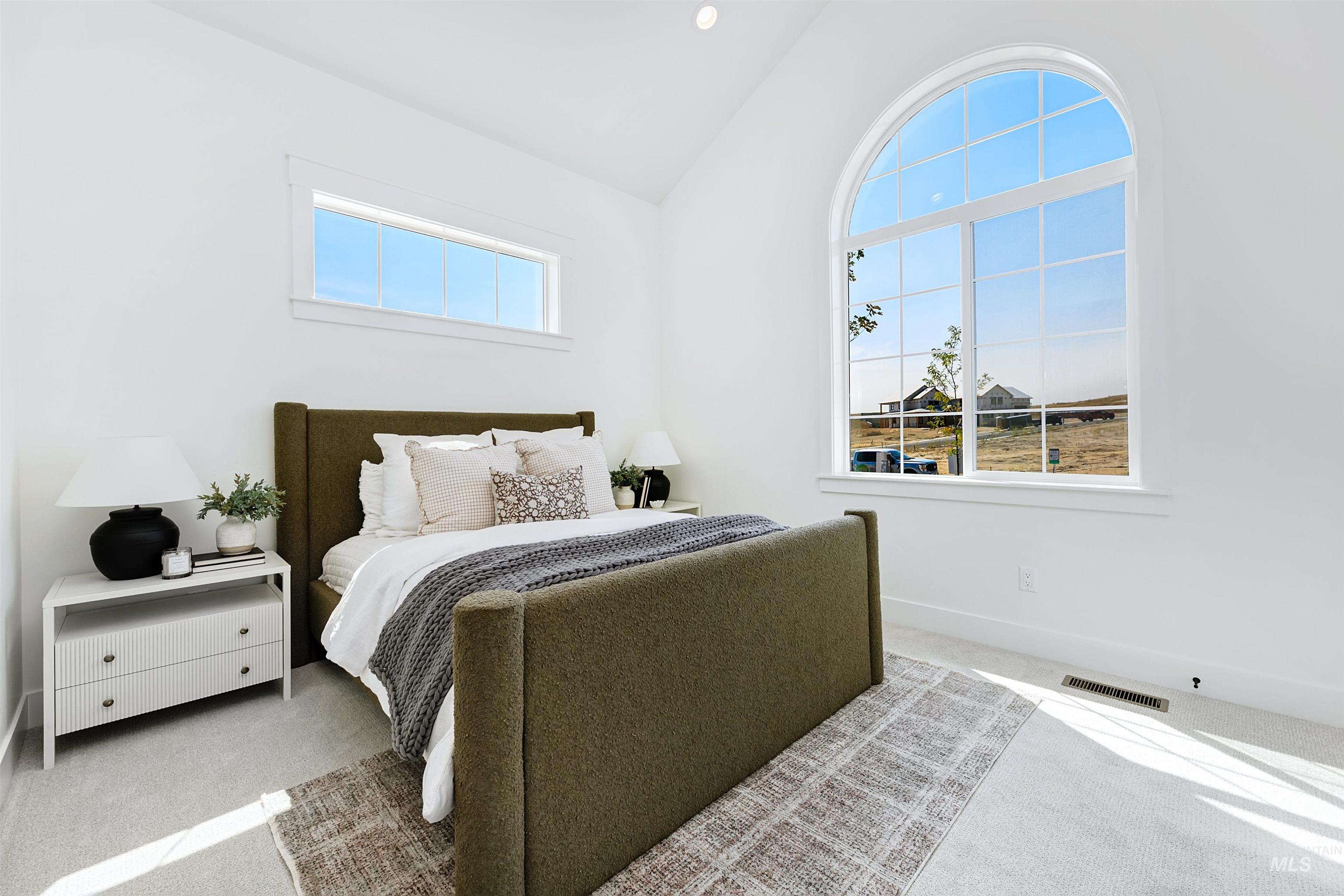 Carpeted bedroom featuring lofted ceiling and baseboards