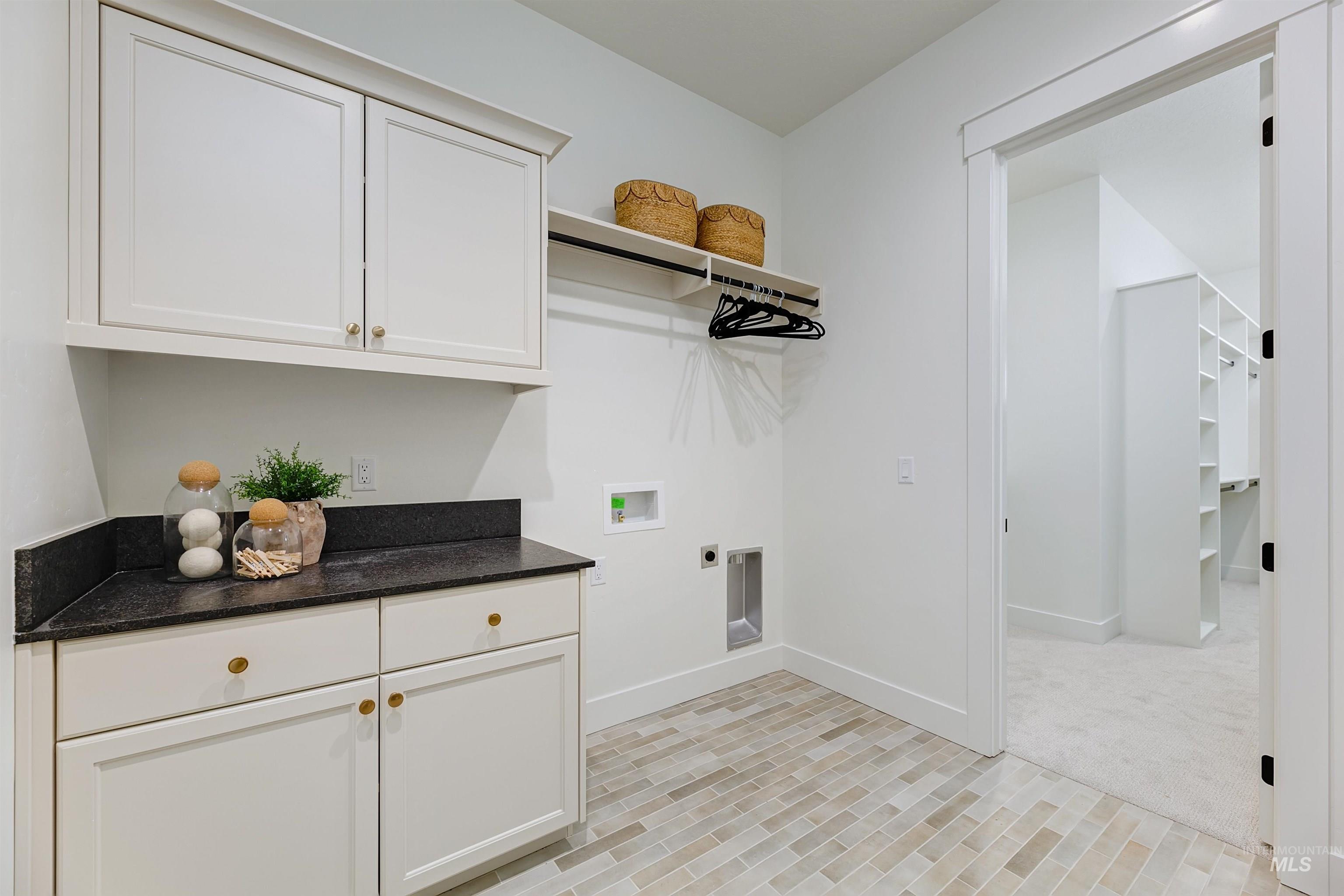 Washroom with hookup for a washing machine, cabinet space, and electric dryer hookup