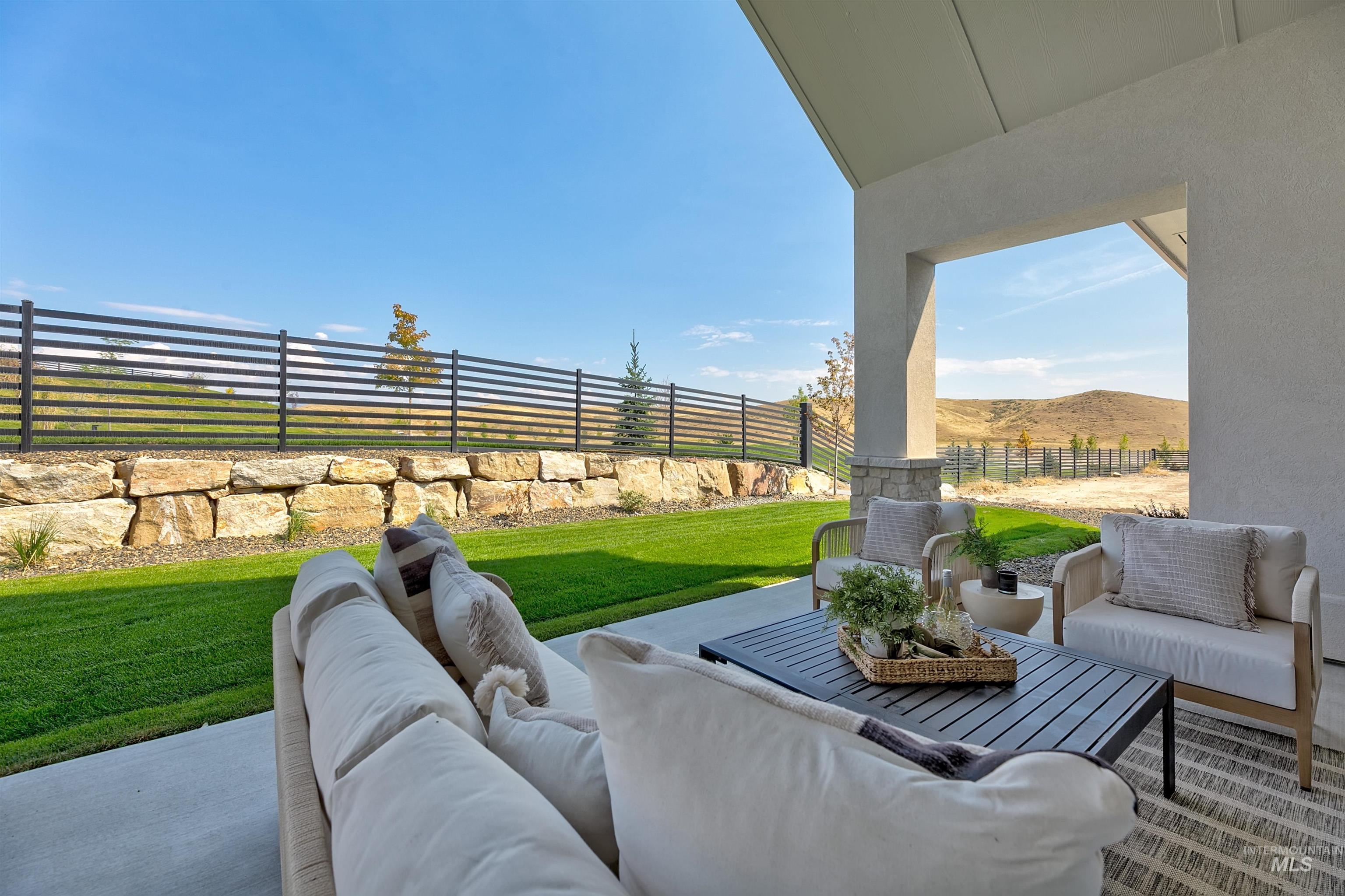 Fenced backyard with an outdoor living space, a patio, and a mountain view