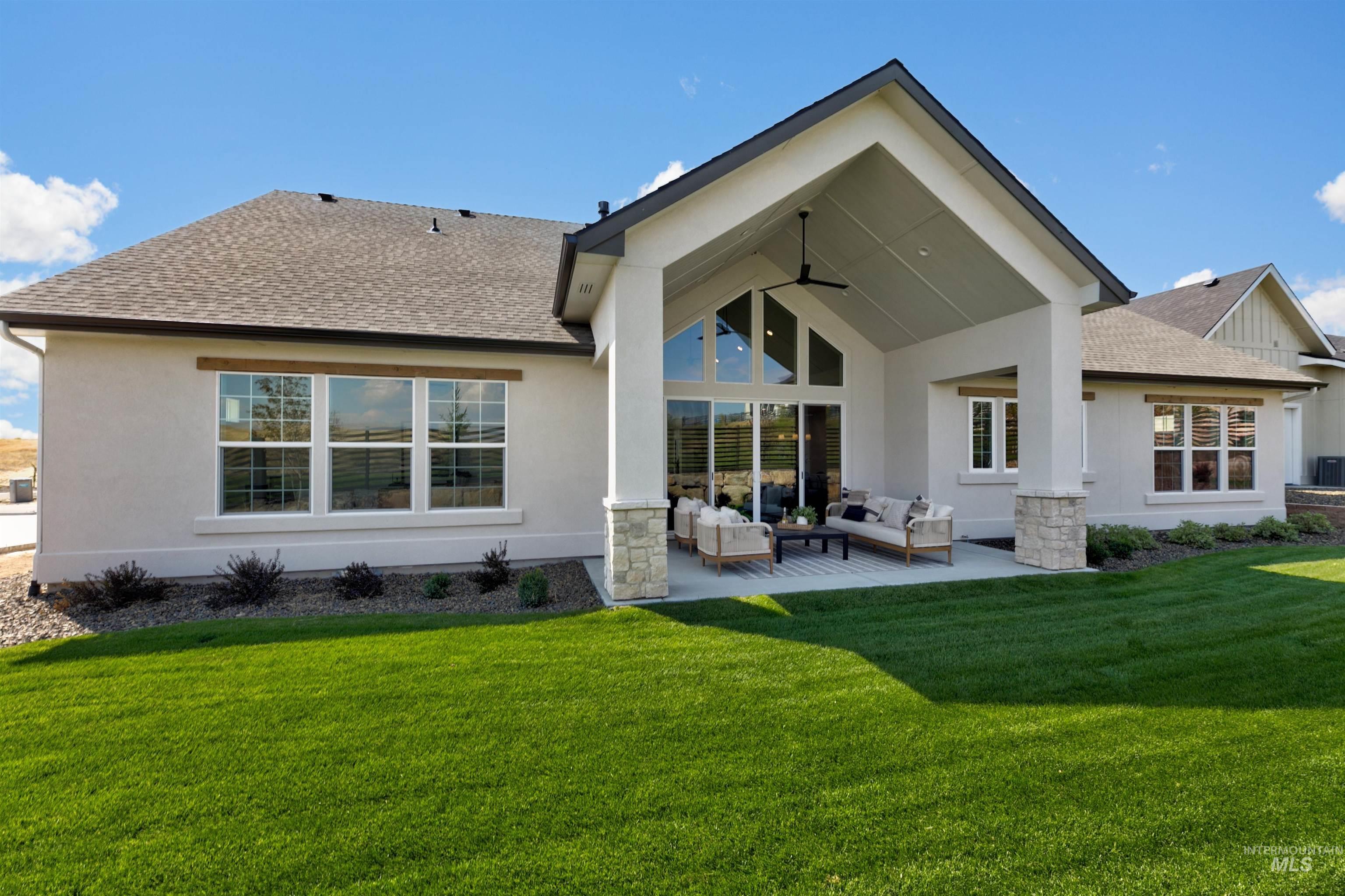Rear view of property featuring roof with shingles, outdoor lounge area, a patio area, a ceiling fan, and stucco siding