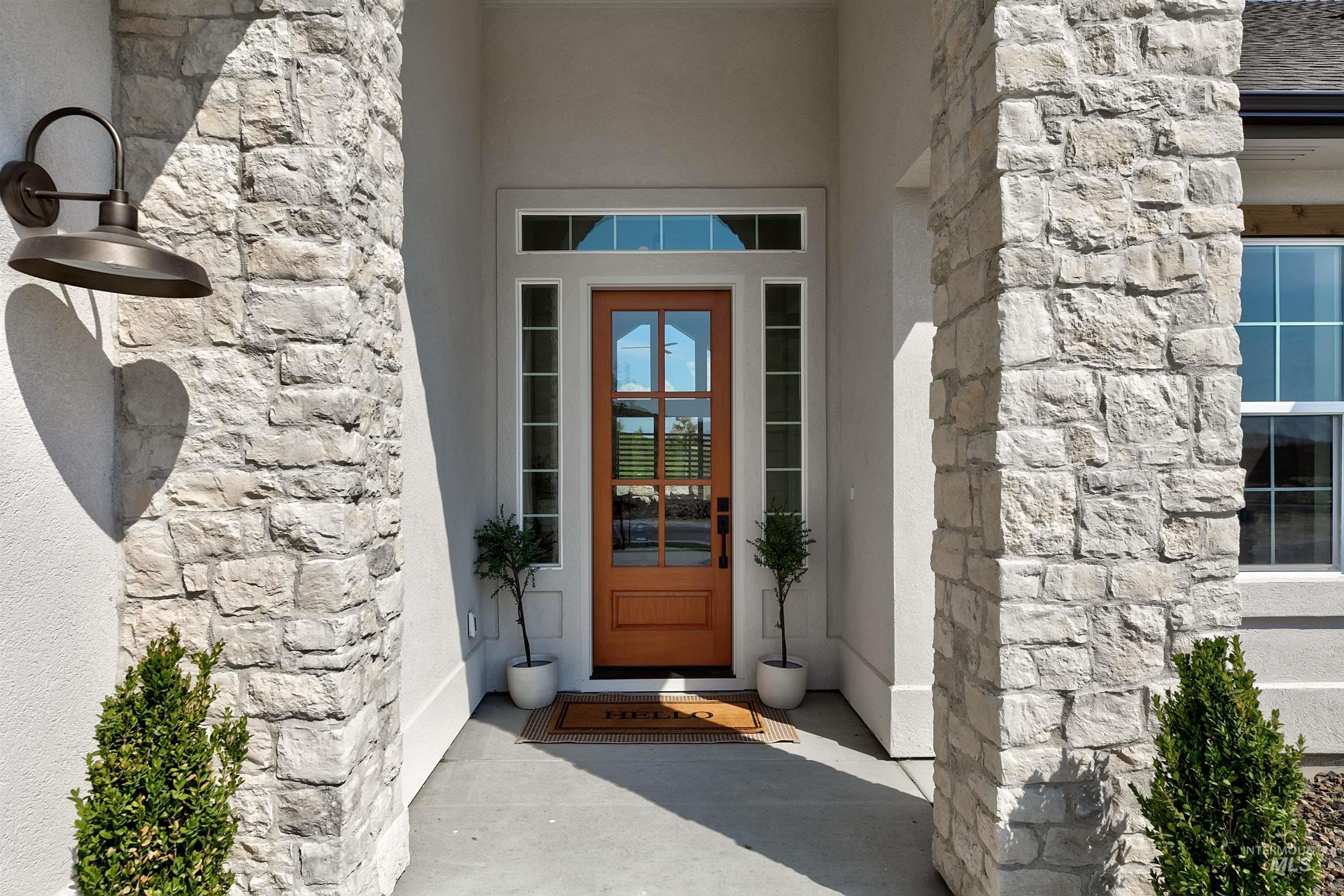 View of exterior entry with stone siding and stucco siding