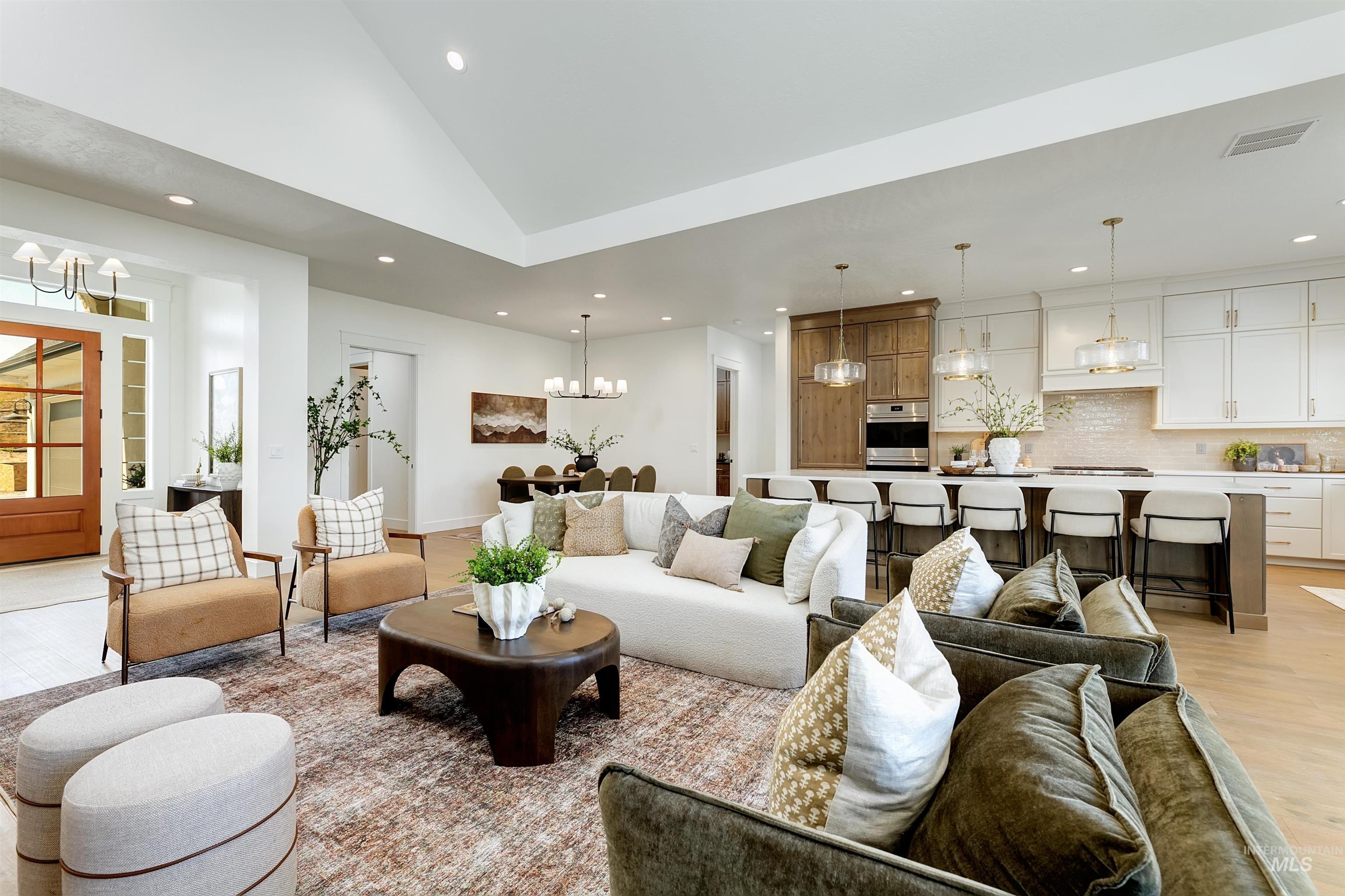Living room featuring light wood finished floors, a chandelier, recessed lighting, and high vaulted ceiling