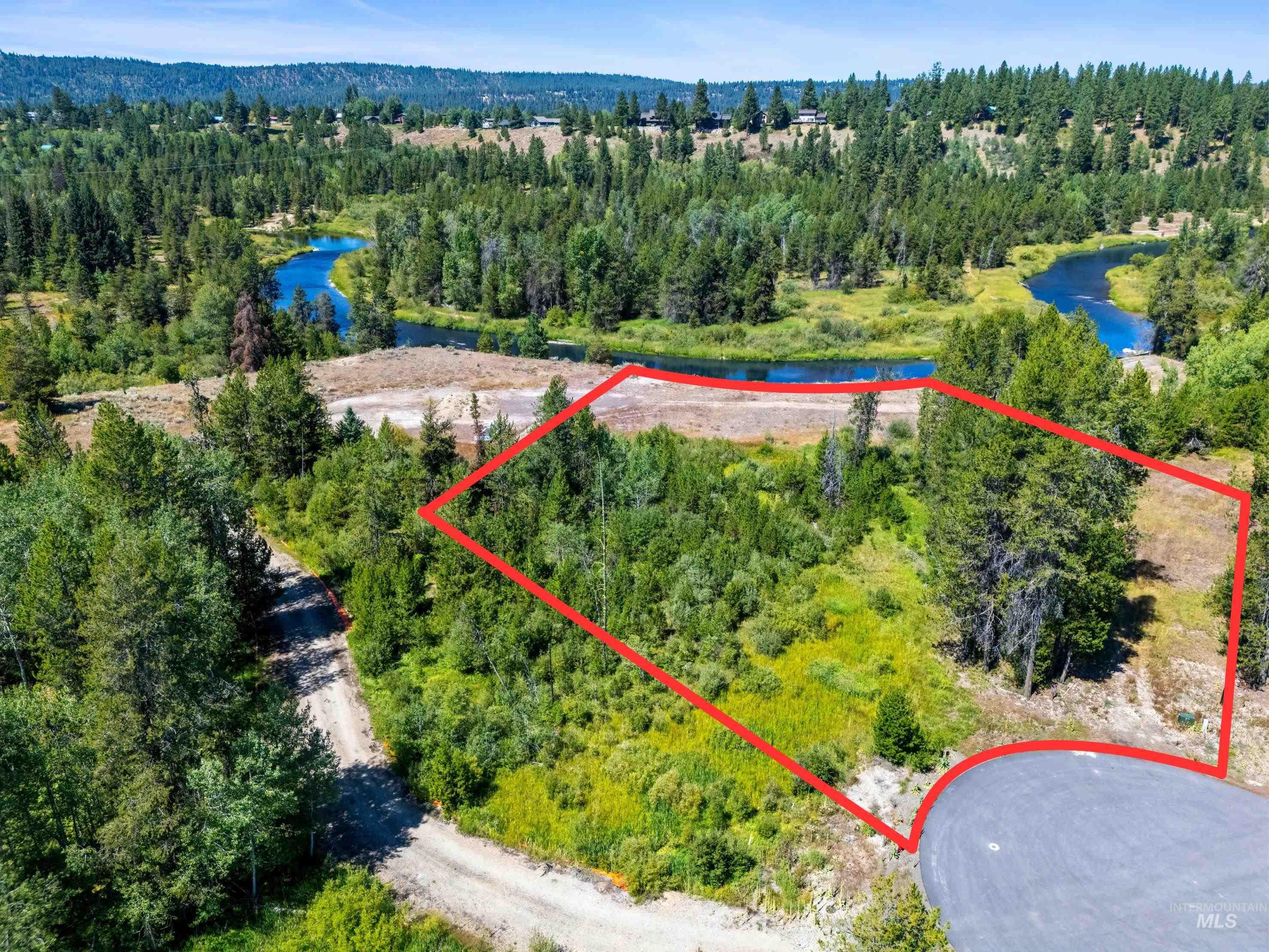 Aerial view of property's location with property parcel outlined and a large body of water