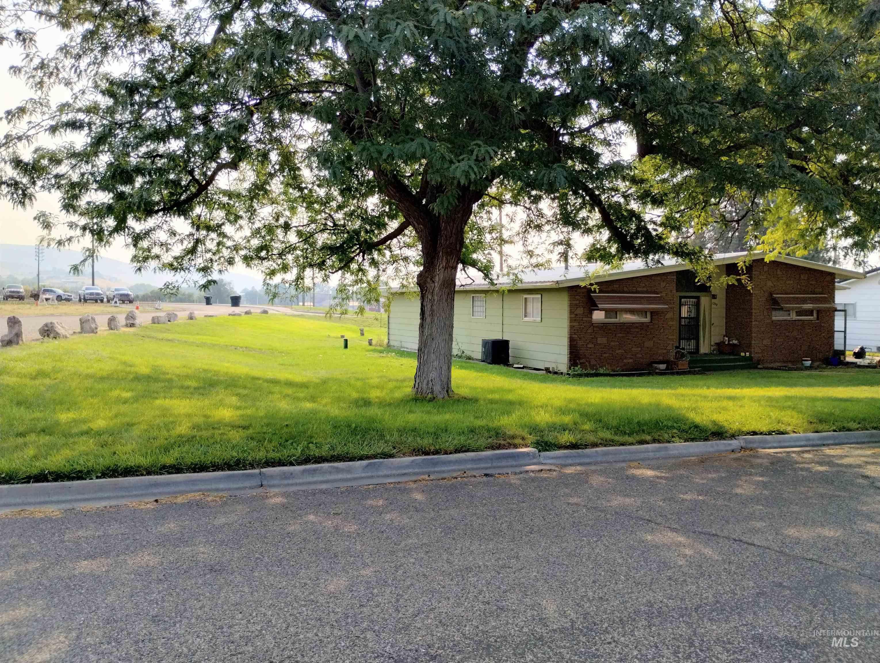 View of home's exterior with a lawn and brick siding