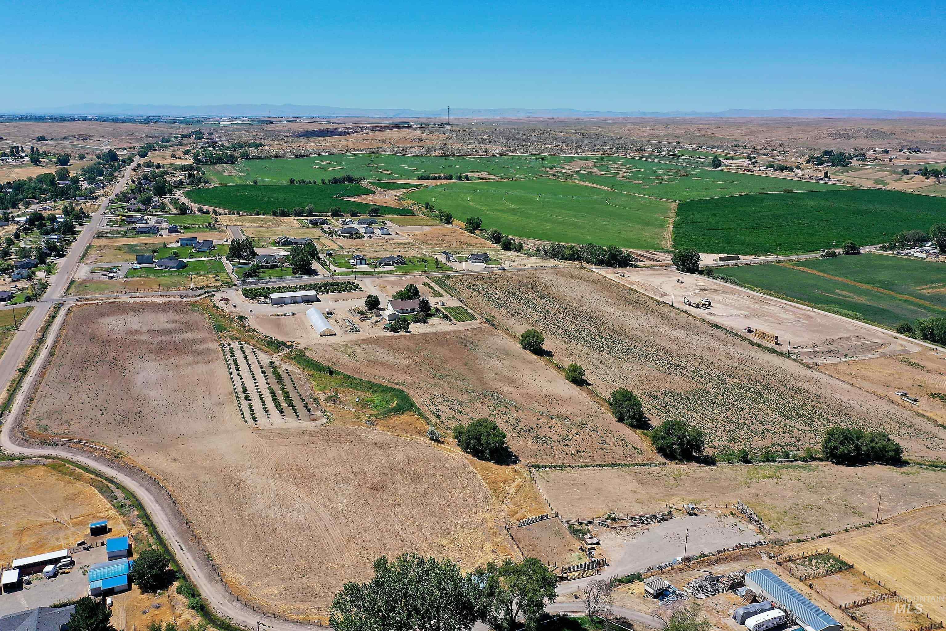 Aerial view of property and surrounding area with rural landscape, abundant farmland, and mountains