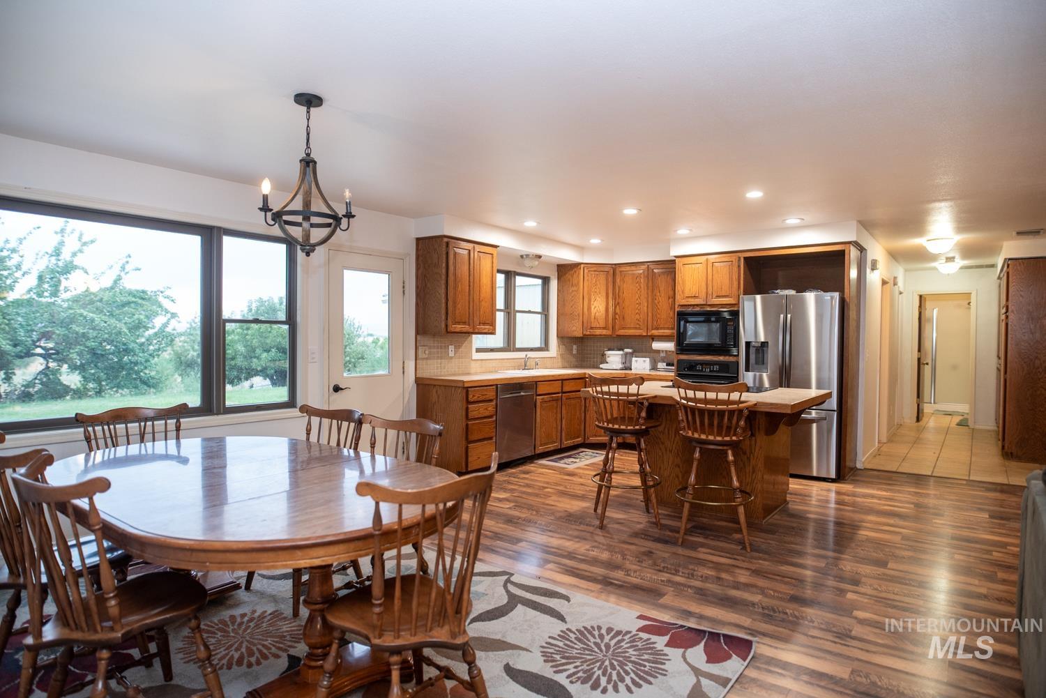 Dining space with dark wood-style flooring, a chandelier, and recessed lighting