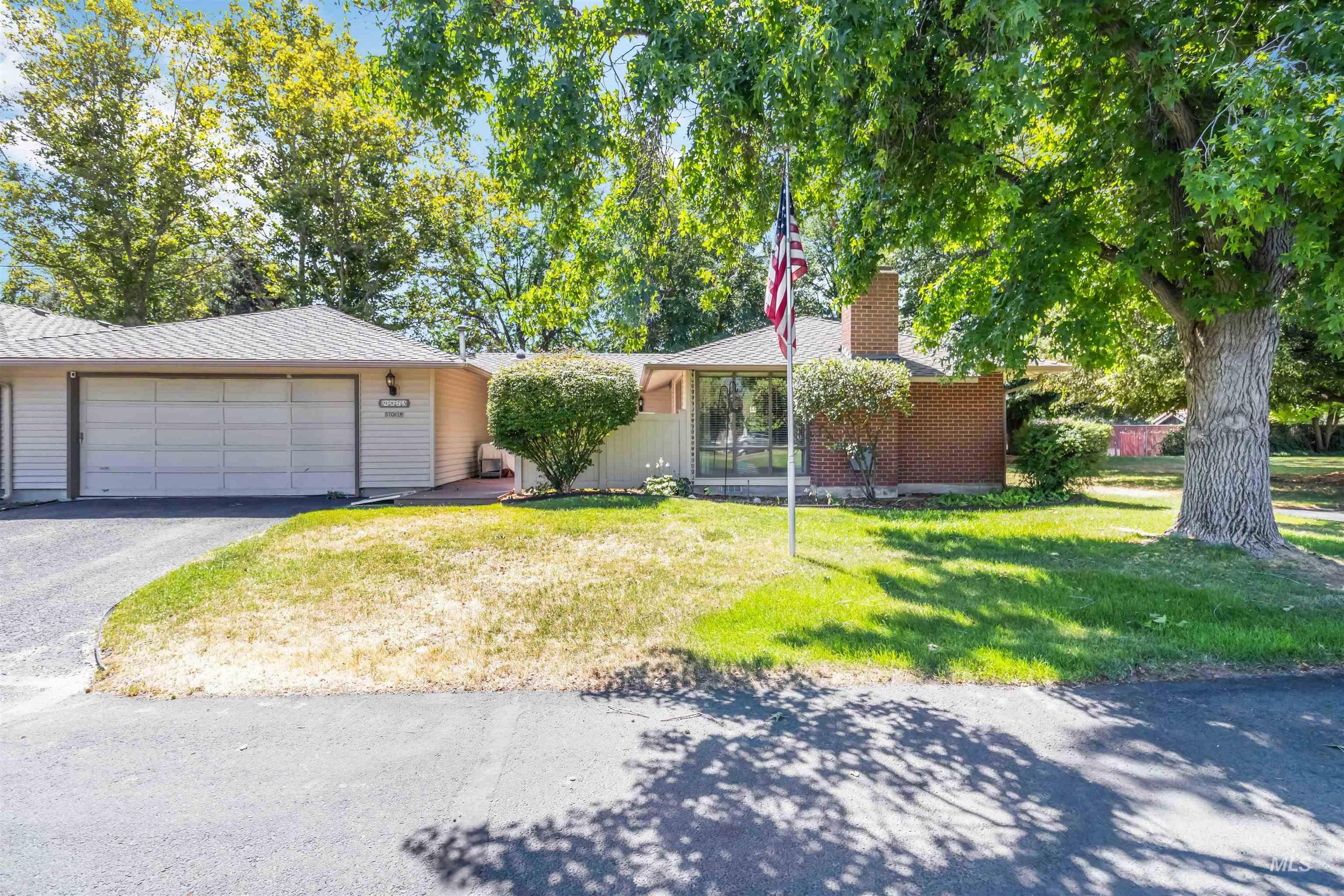 Single story home with a front lawn, a chimney, and driveway