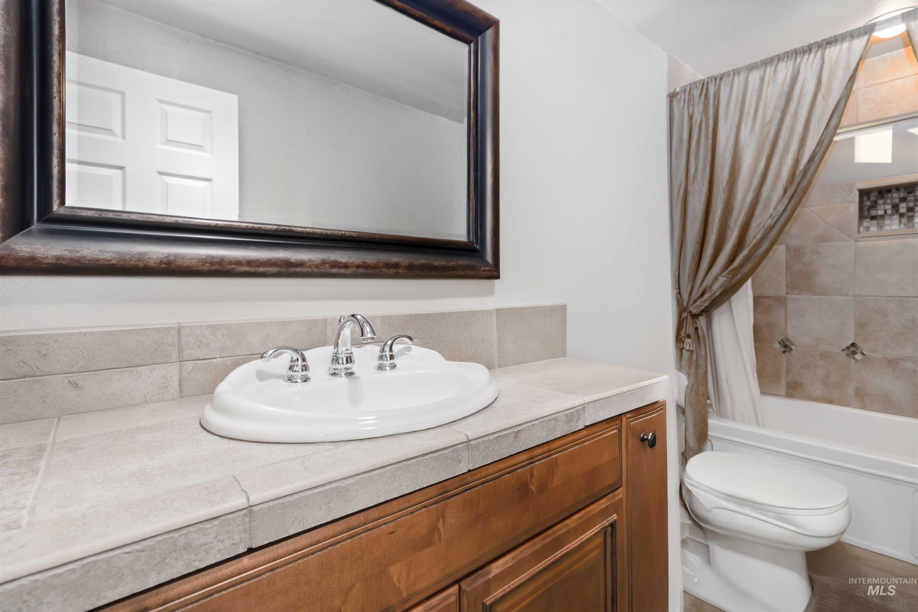 Main Full bath featuring vanity and shower / bathtub combination.