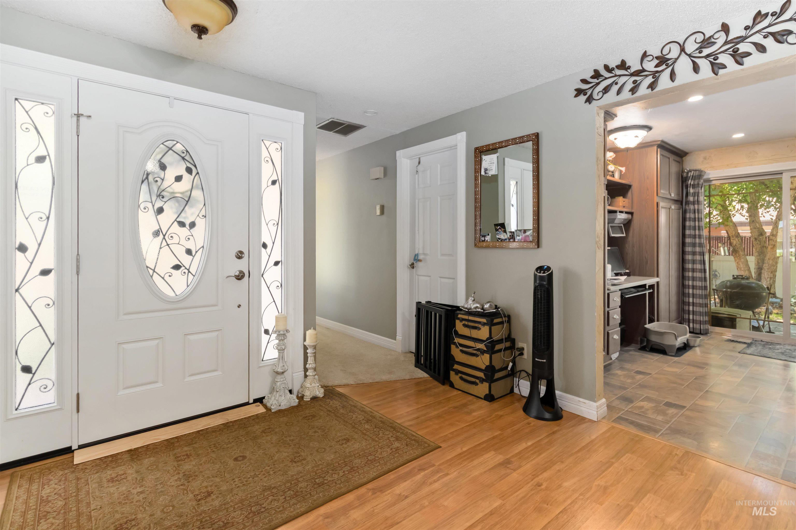 Foyer with light wood-style flooring and baseboards