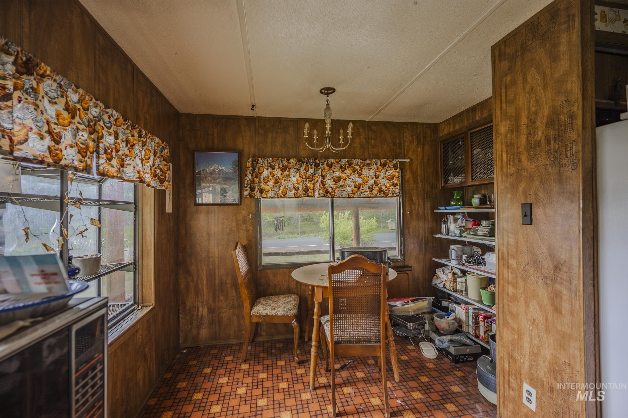 Dining room with wood walls and a chandelier