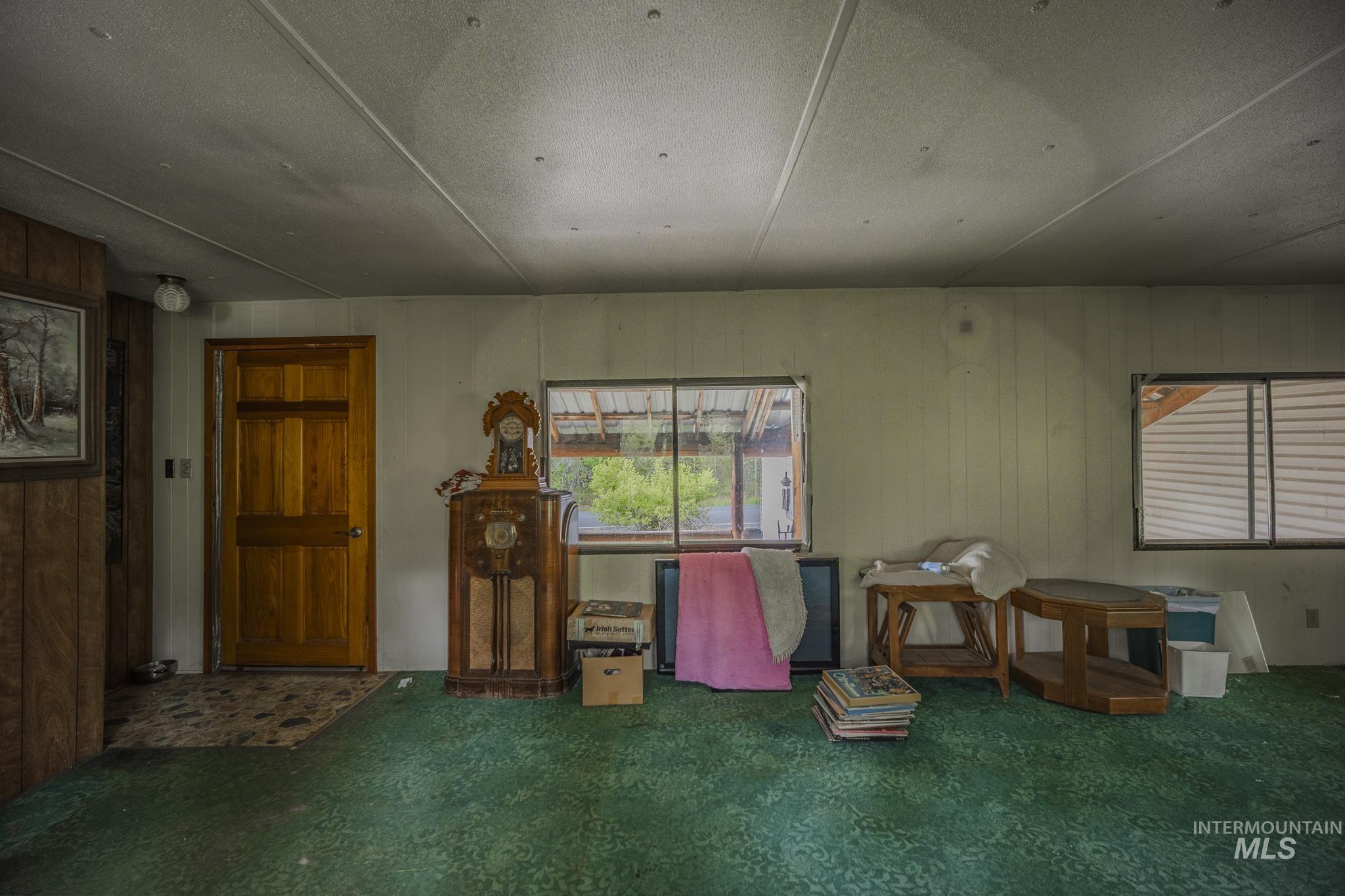 Misc room with healthy amount of natural light and wood walls