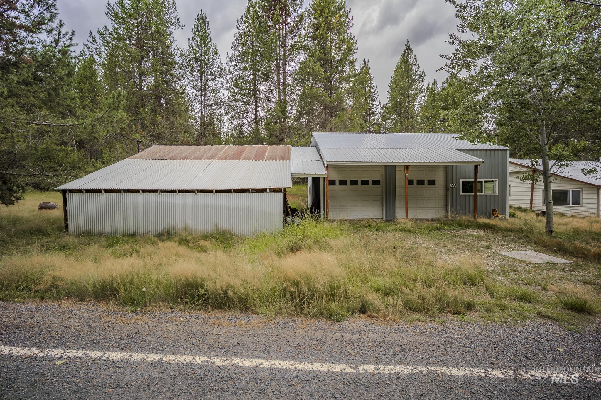 View of front of property featuring an outdoor structure, an outbuilding, and a metal roof