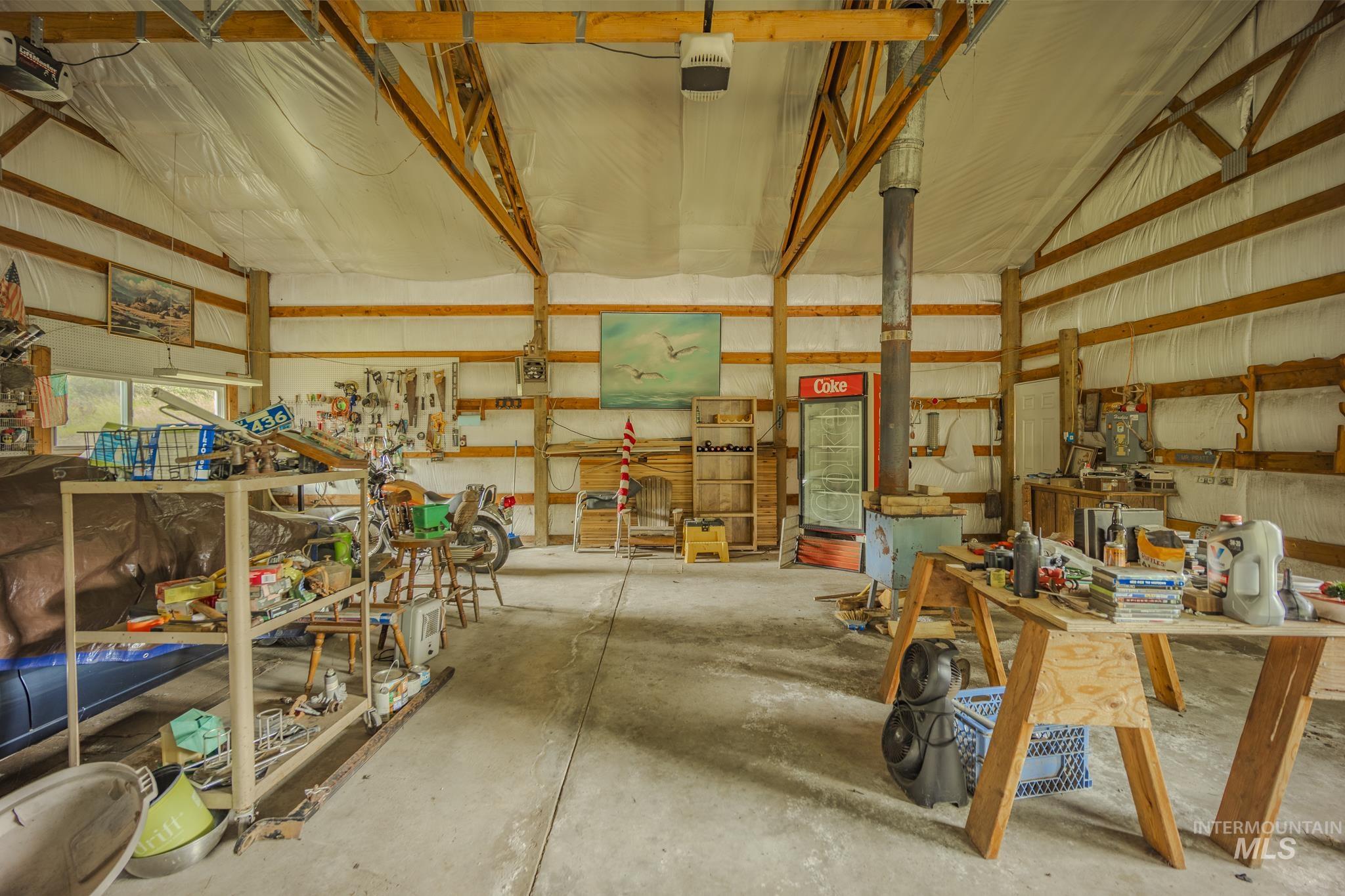 Garage featuring a garage door opener, metal wall, and a workshop area