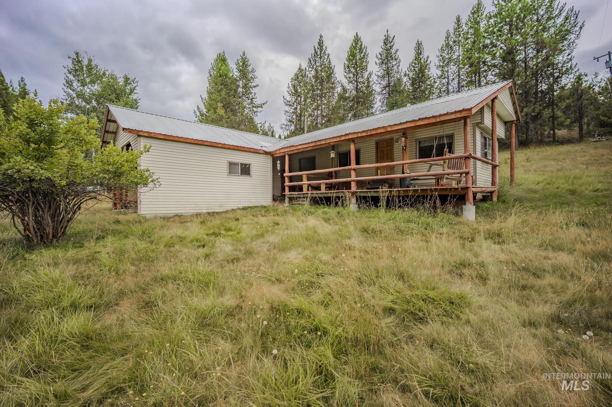 Rear view of house featuring a metal roof and a wooden deck
