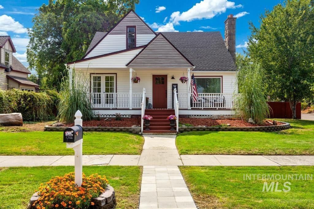 Bungalow-style house featuring a porch, a front yard, a chimney, and a shingled roof