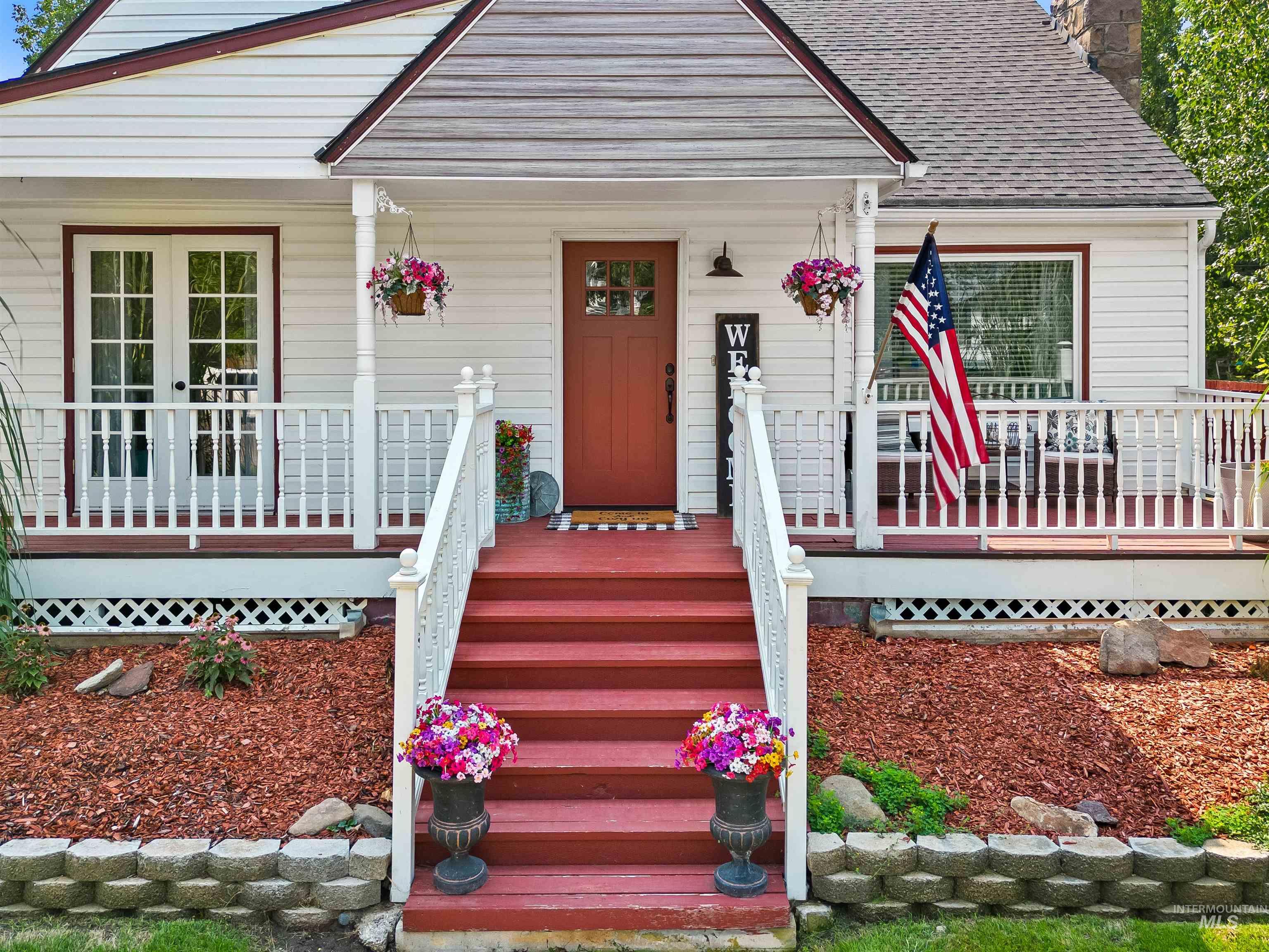 Property entrance with a chimney, a porch, and roof with shingles