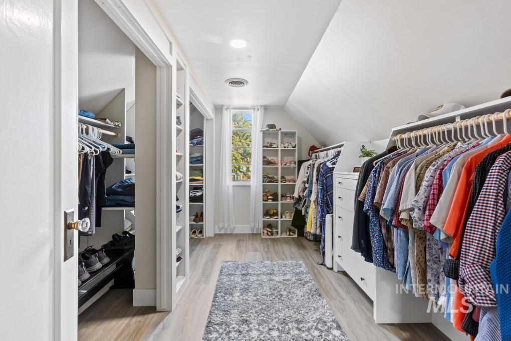 Spacious closet featuring vaulted ceiling and light wood-type flooring