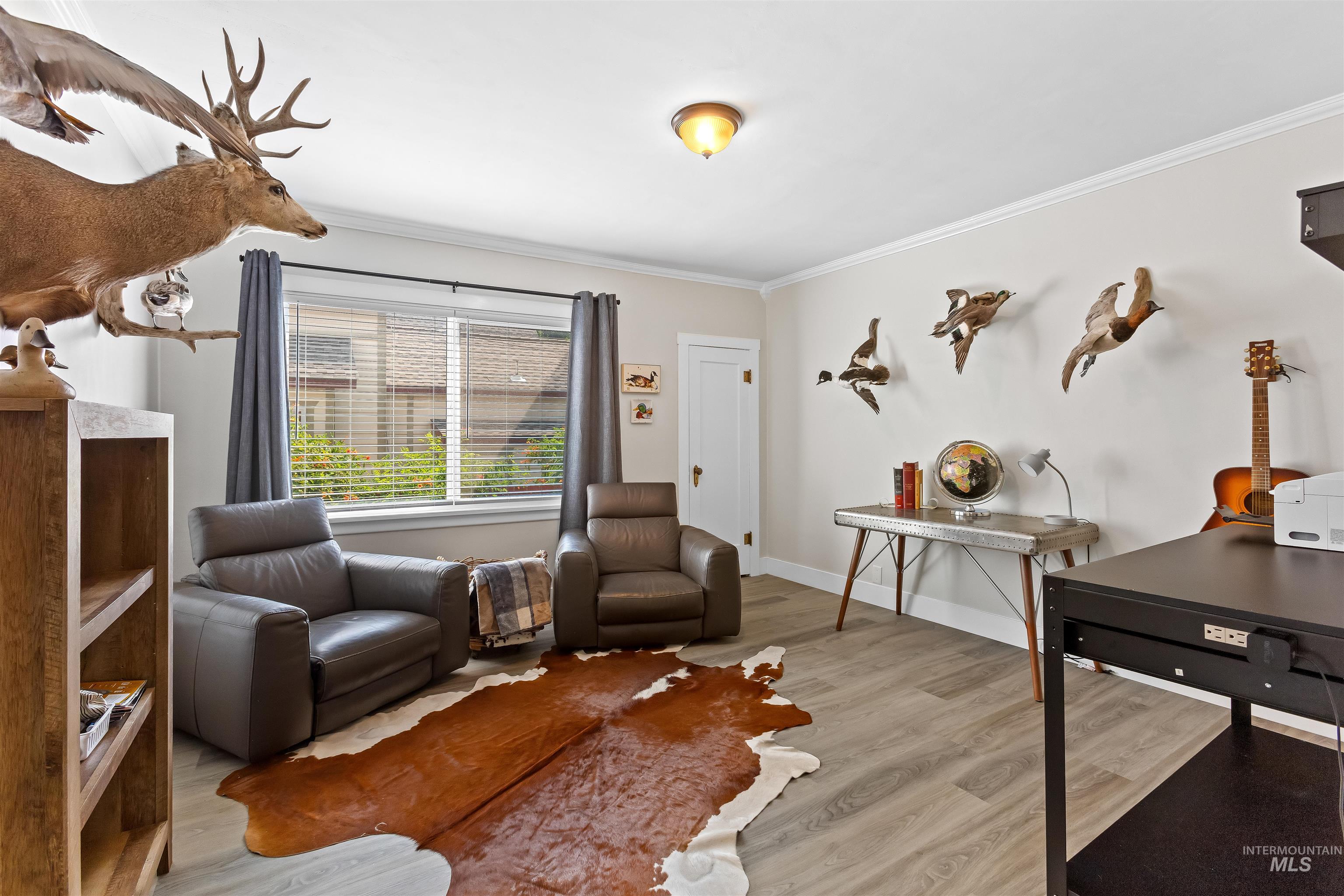 Office space with light wood-style flooring and crown molding