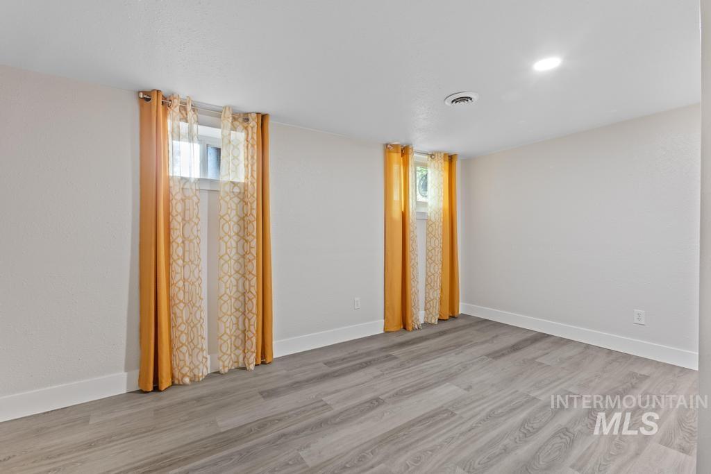 Unfurnished room with baseboards and light wood-style floors